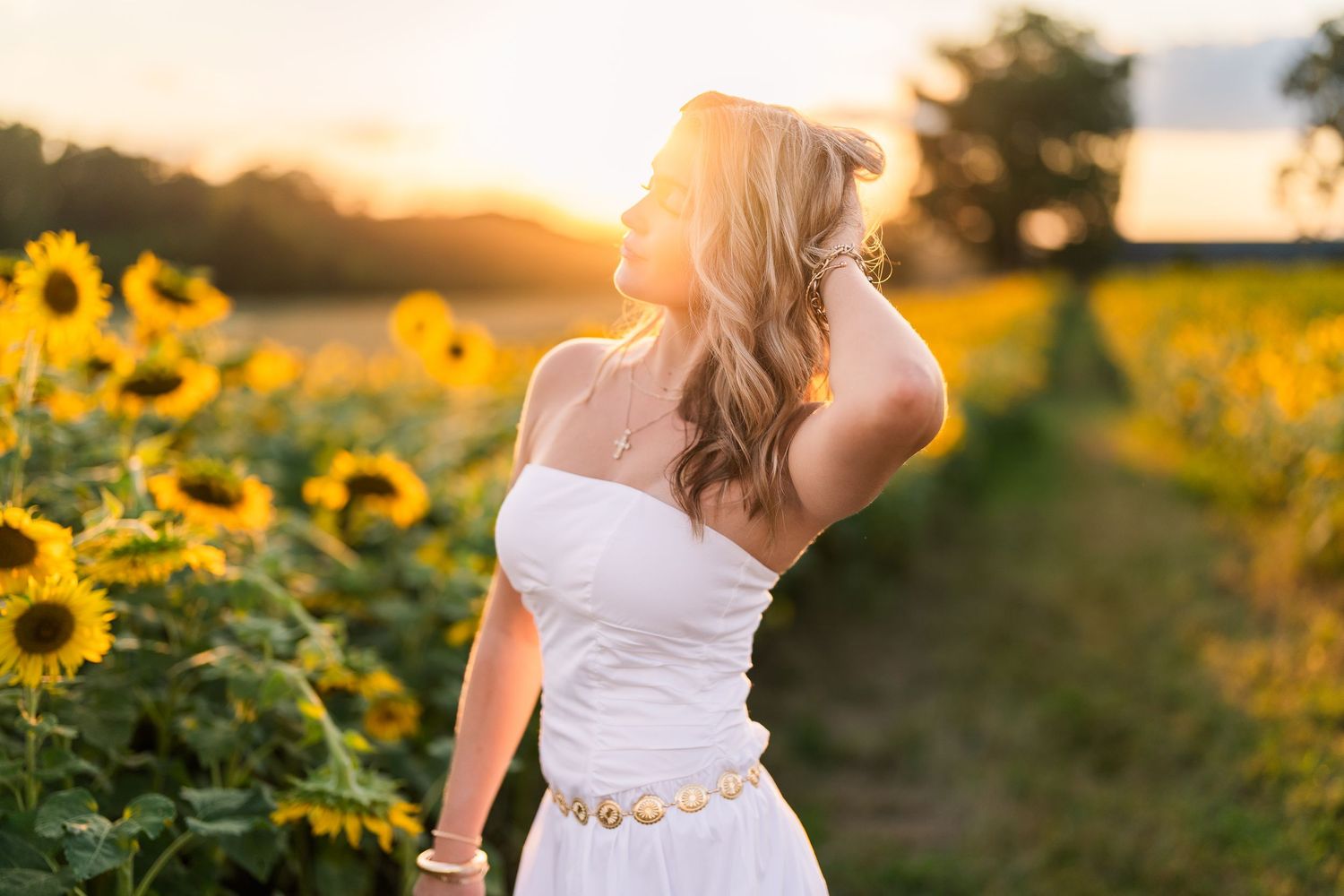 Greensboro, NC Senior Photographer, Reidsville, NC.  Ryan Harden. Stunning senior portrait with girl posing in field of sunflowers at sunset