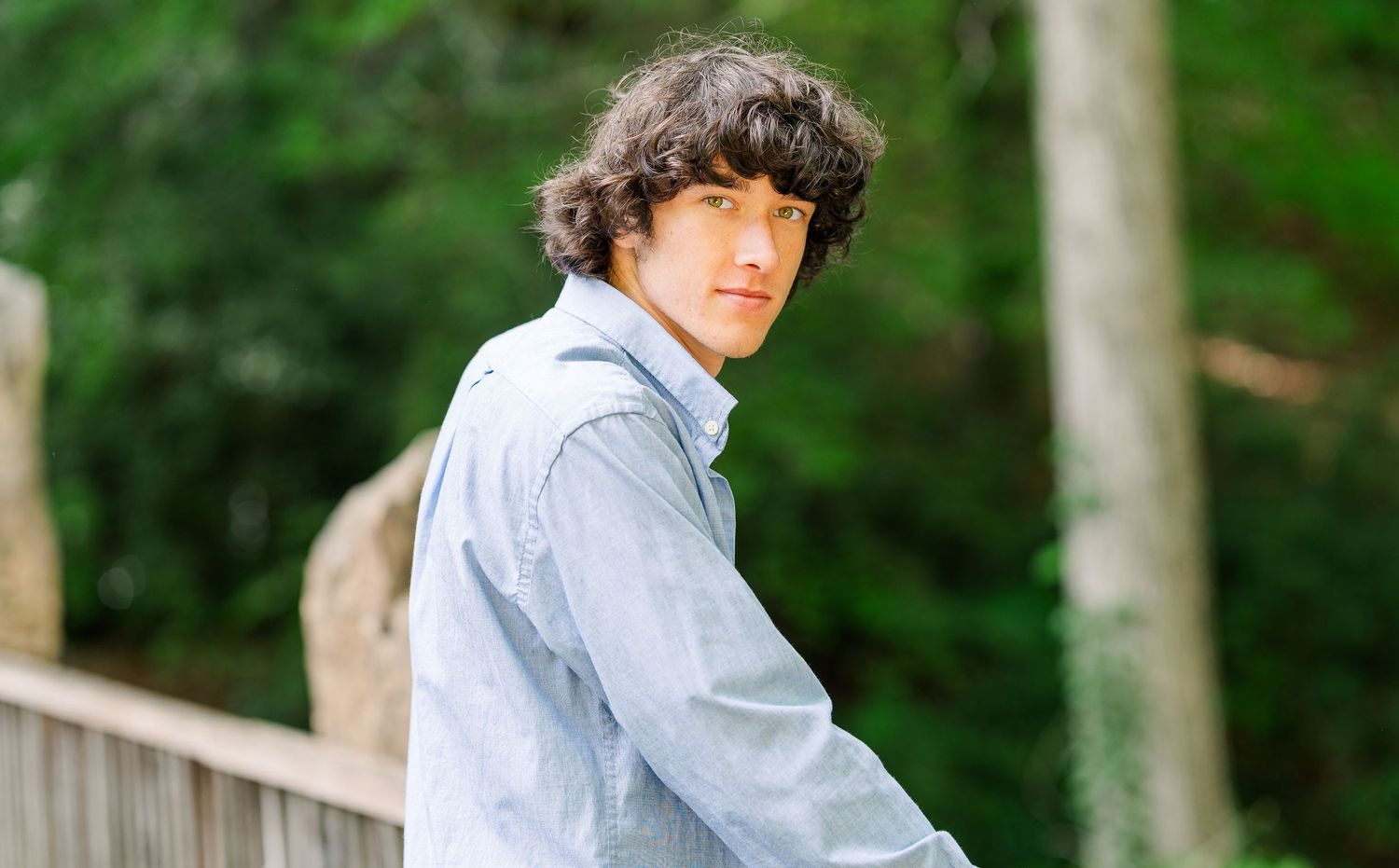 Greensboro, NC Senior Photographer.  Ryan Harden.  Reidsville, NC.  Male looking over shoulder as golden light hits his face.  Green eyes.