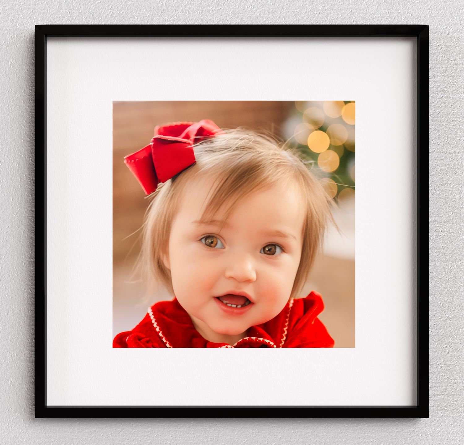 Greensboro, NC Family Photographer, Ryan Harden, Reidsville NC, framed portrait of toddler girl with red bow in front of Christmas tree.