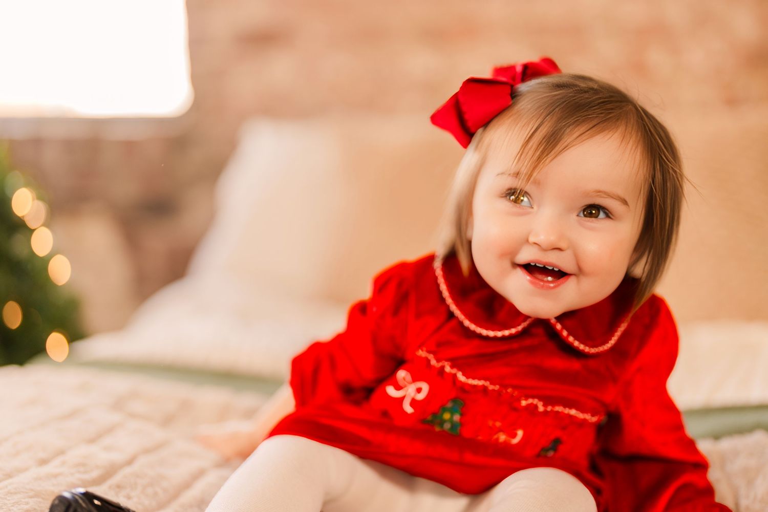 Greensboro, NC Family Photographer, Ryan Harden, Reidsville NC, little girl smiles in front of Christmas tree for seasonal session.