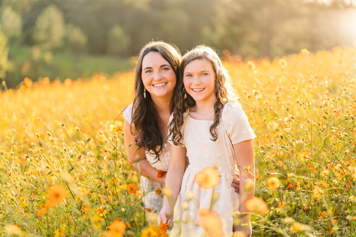 Greensboro, NC Family Photographer, Reidsville, NC.  Ryan Harden.  Mom and daughter in field of flowers and golden sunset falls behind them.