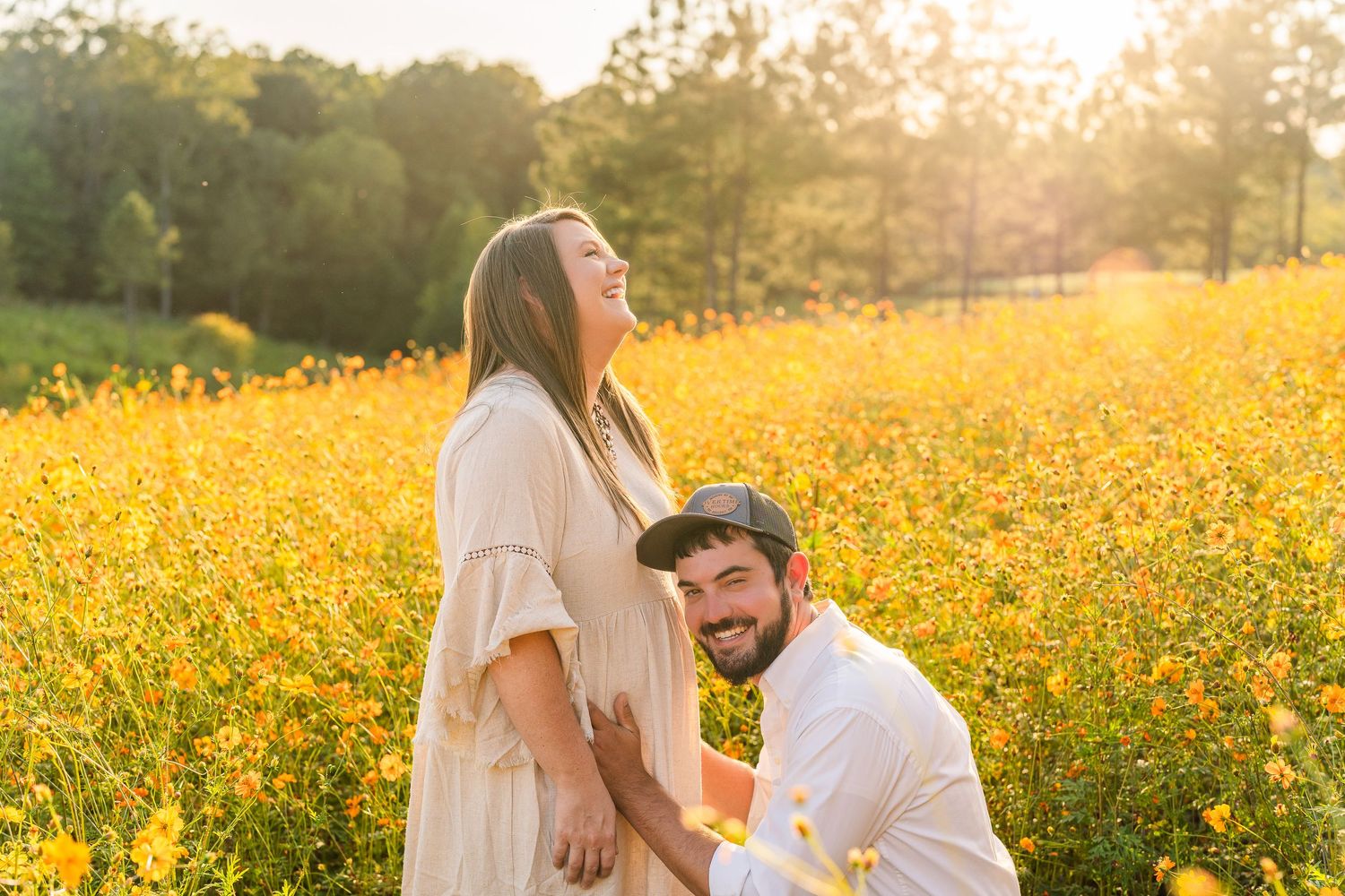 Greensboro, NC Family Photographer, Reidsville, NC.  Ryan Harden.  Husband and wife in field of flowers and golden sunset falls behind them.