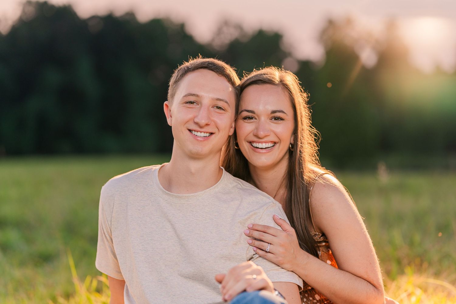 Greensboro, NC Couples Photographer, Ryan Harden, Reidsville NC, loving couple holds each other in a lush green field at sunset.