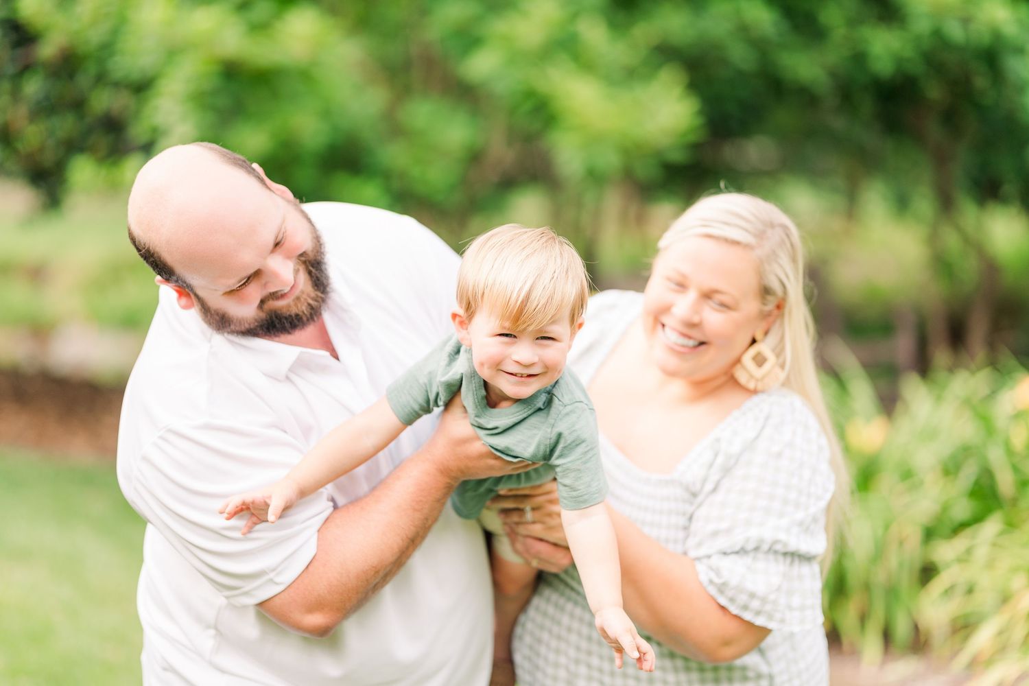 Greensboro, NC Family Photographer, Ryan Harden, Reidsville NC, happy family flies son at Tanger Family Bicentennial Gardens.