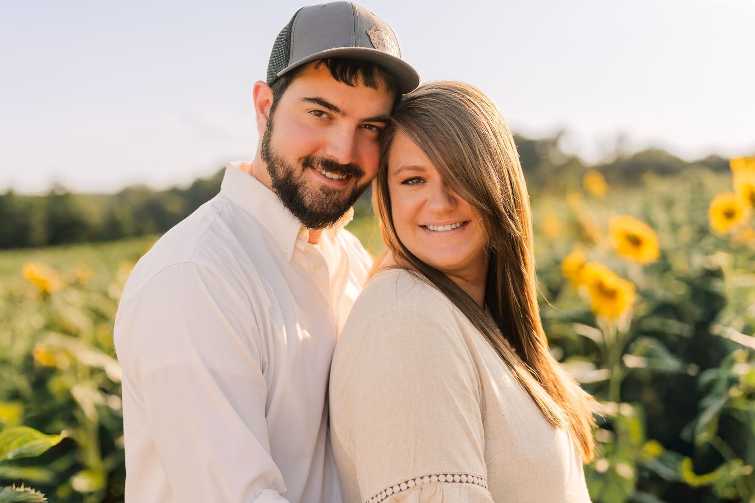 Greensboro, NC Family Photographer, Reidsville, NC.  Ryan Harden.  Husband and Wife in field of sunflowers.