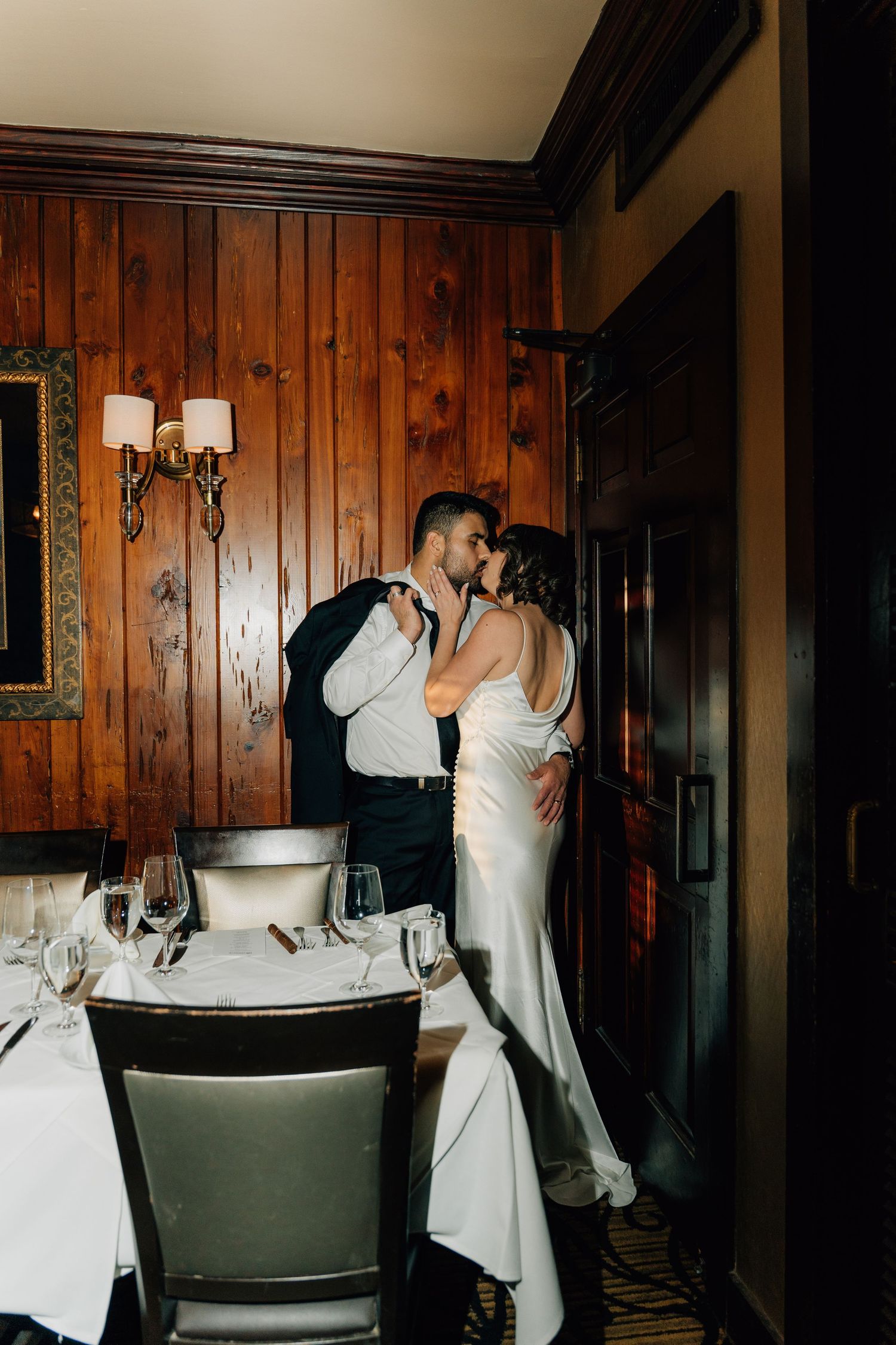 Intimate moments captured in a rustic wood-paneled room with vintage decor.