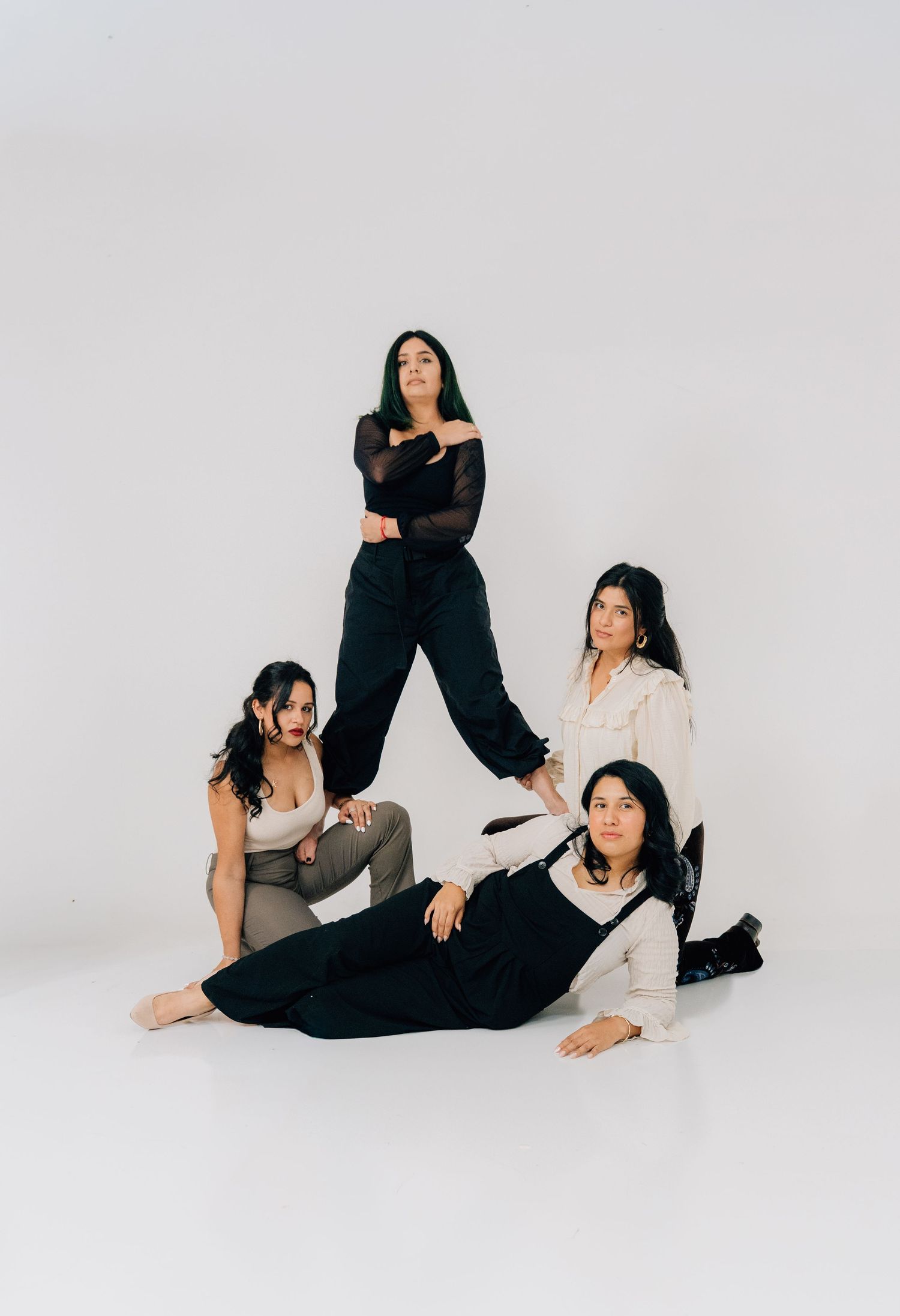 Artistic group portrait with contrasting black and white outfits in contemporary studio setting.