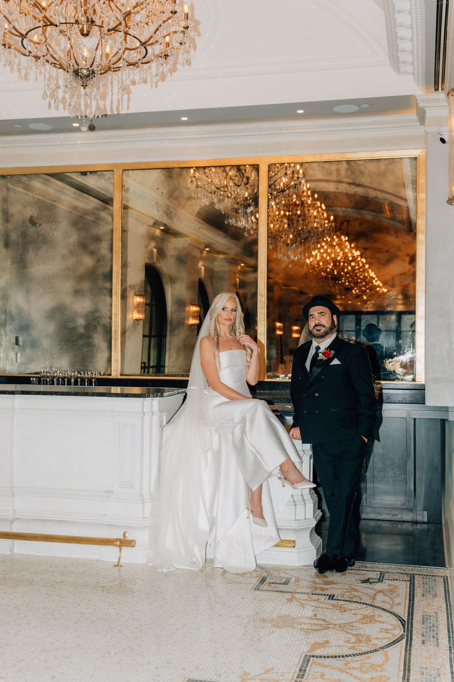 Elegant wedding venue interior with crystal chandeliers and romantic lighting.