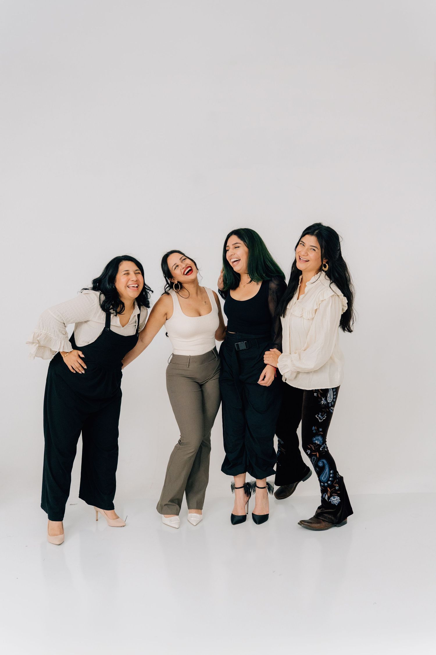 Group laughs together in casual pose wearing coordinated monochromatic outfits.