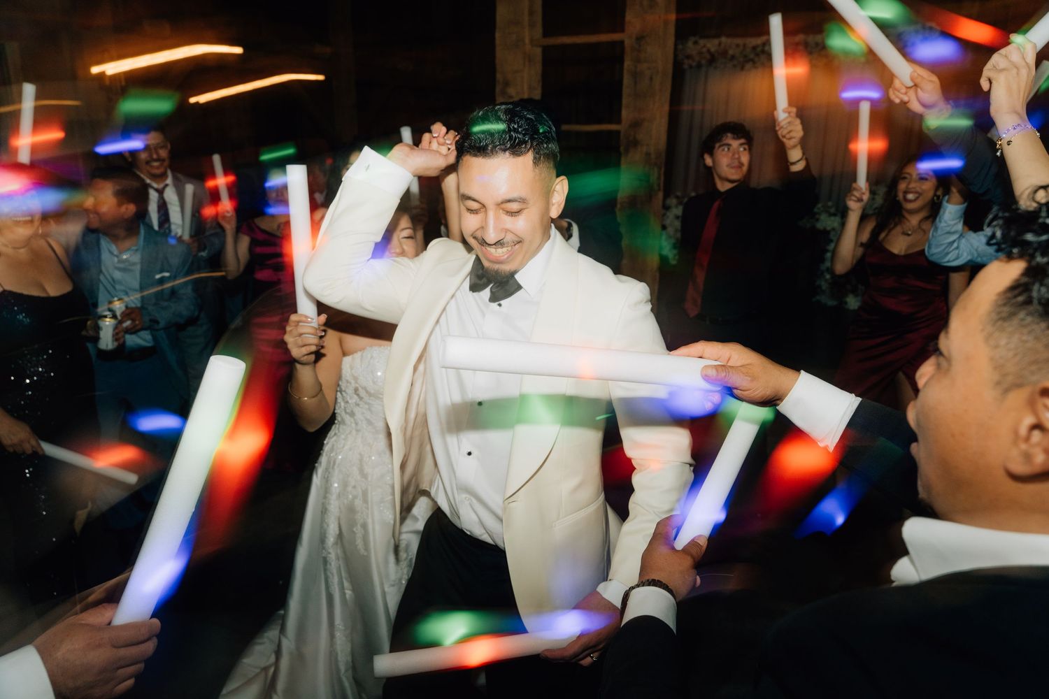 Wedding reception dance floor filled with colorful lights and celebration.
