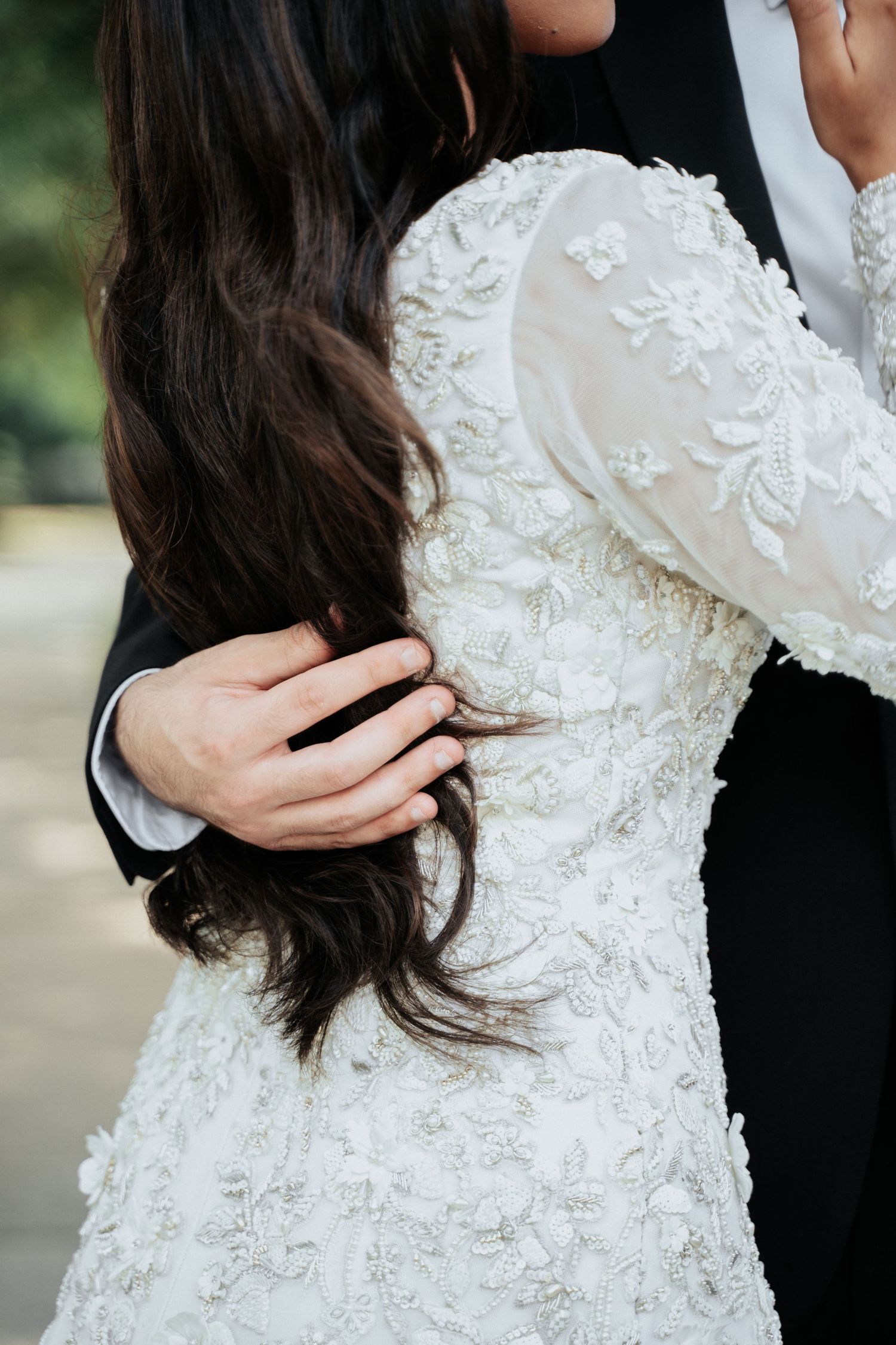 Close-up details of intricate white lace wedding dress with delicate floral embroidery.