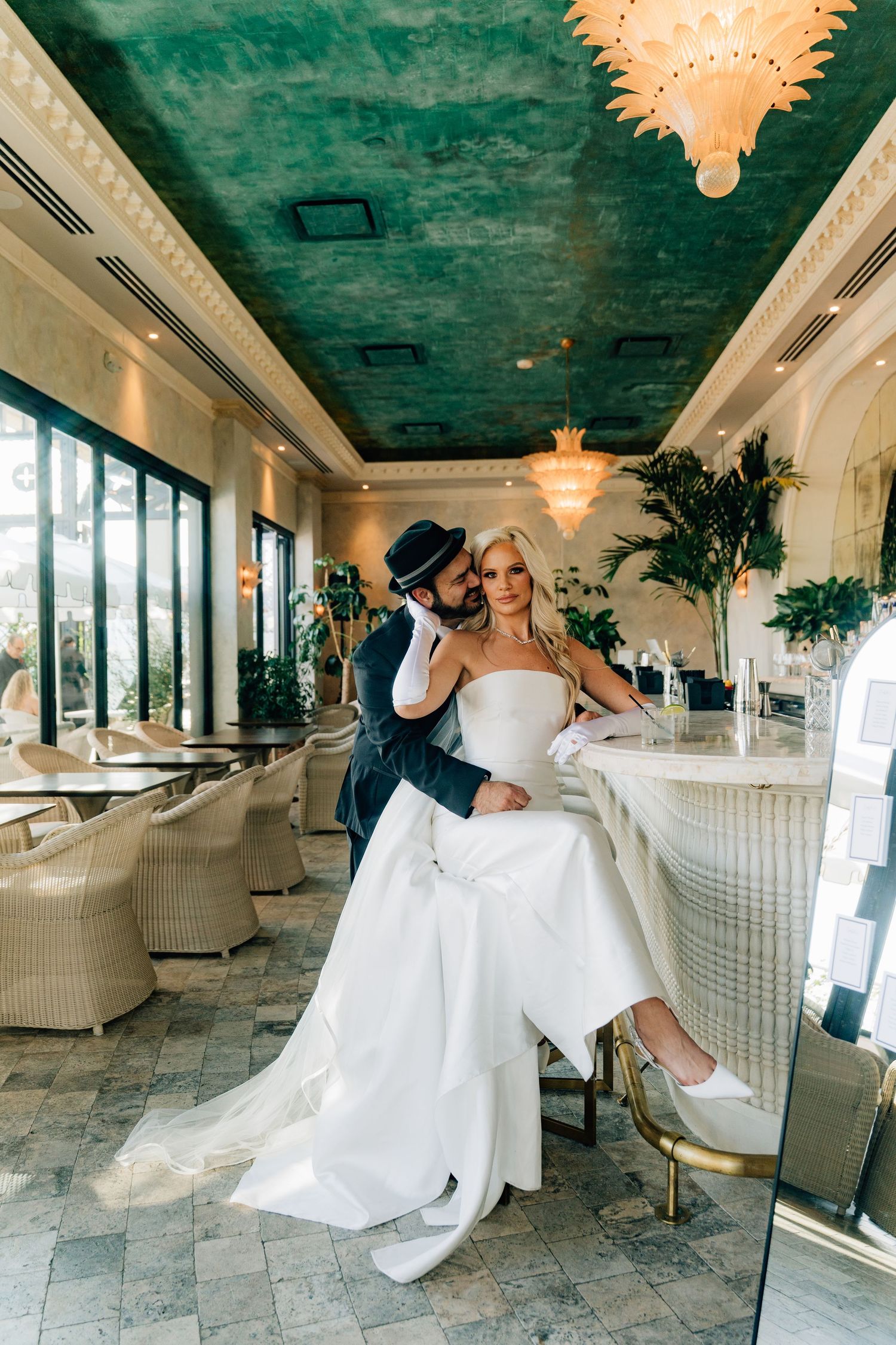 Elegant wedding venue with teal ceiling, white furniture, and dramatic lighting.
