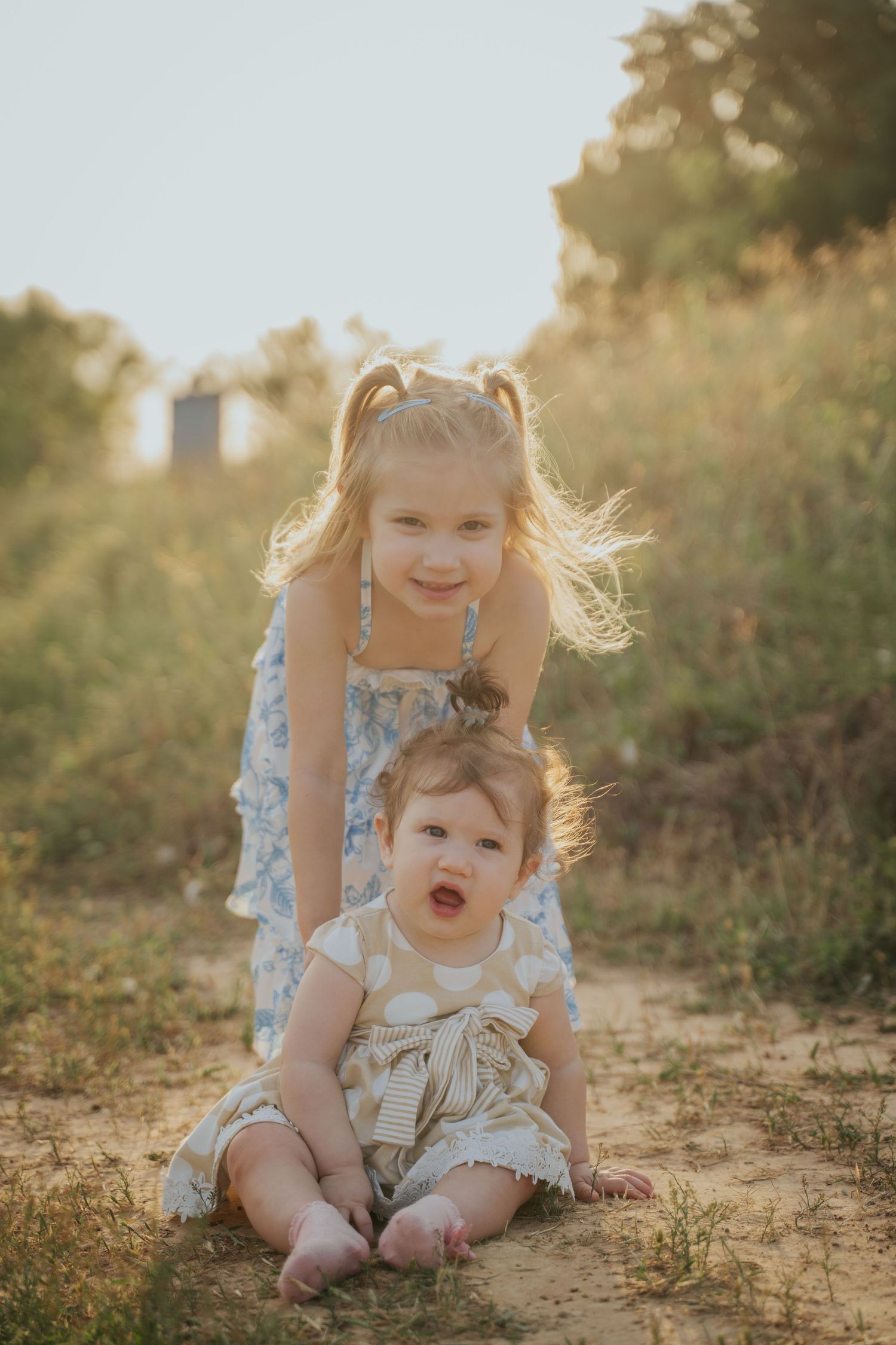 Sweet moments between children playing in golden sunlight on a hill.