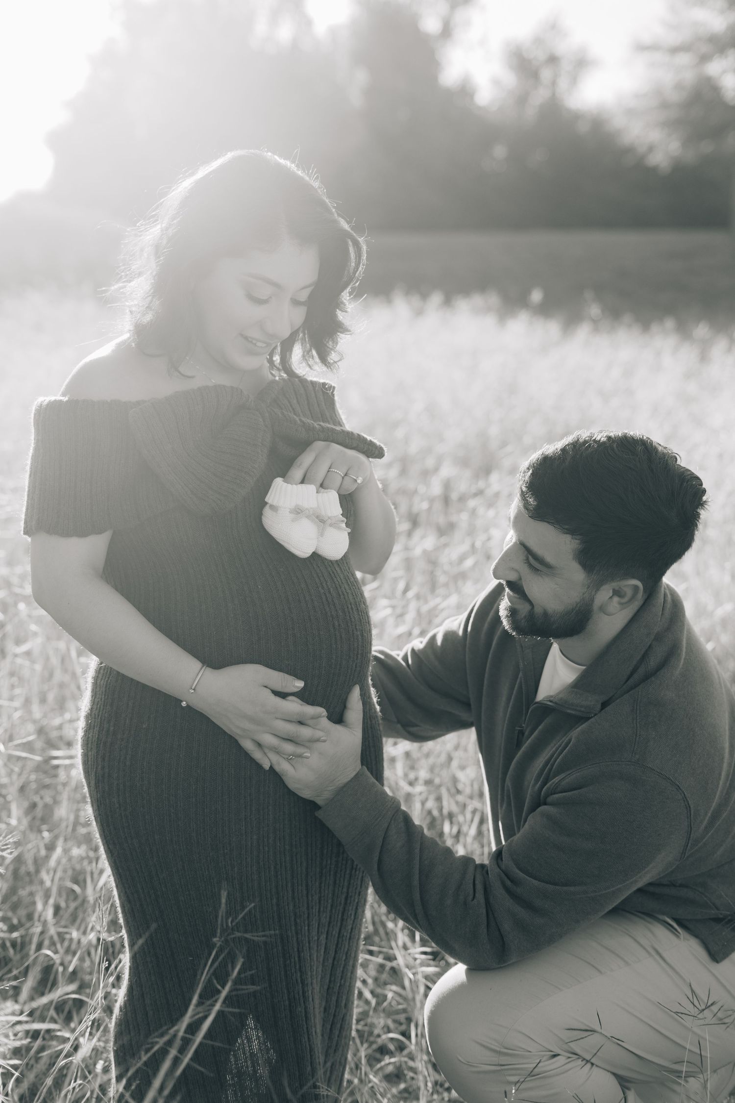 Romantic black and white photo sequence of a couple embracing in a sunlit field.