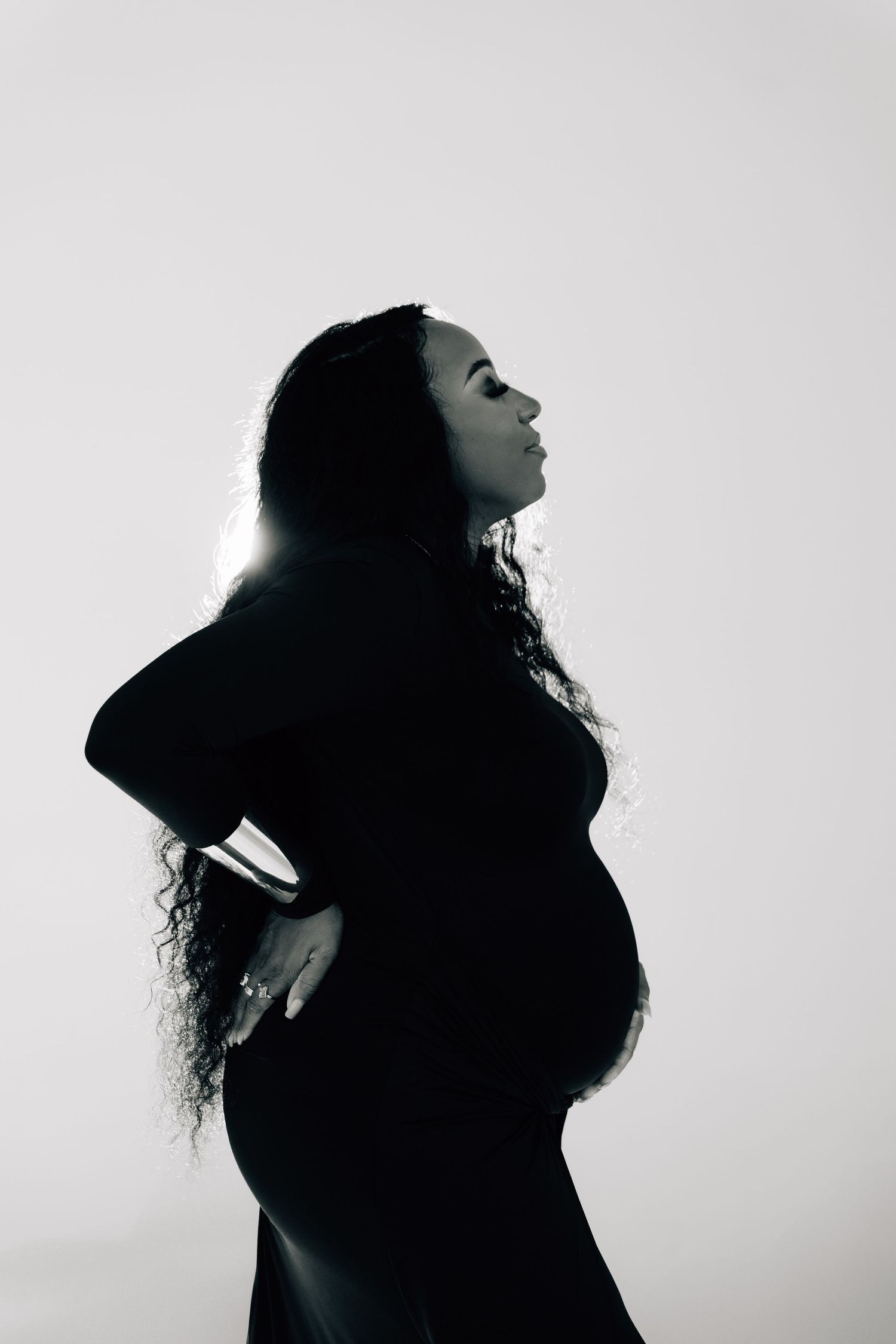 Artistic silhouette portraits of person with curly hair against bright background.
