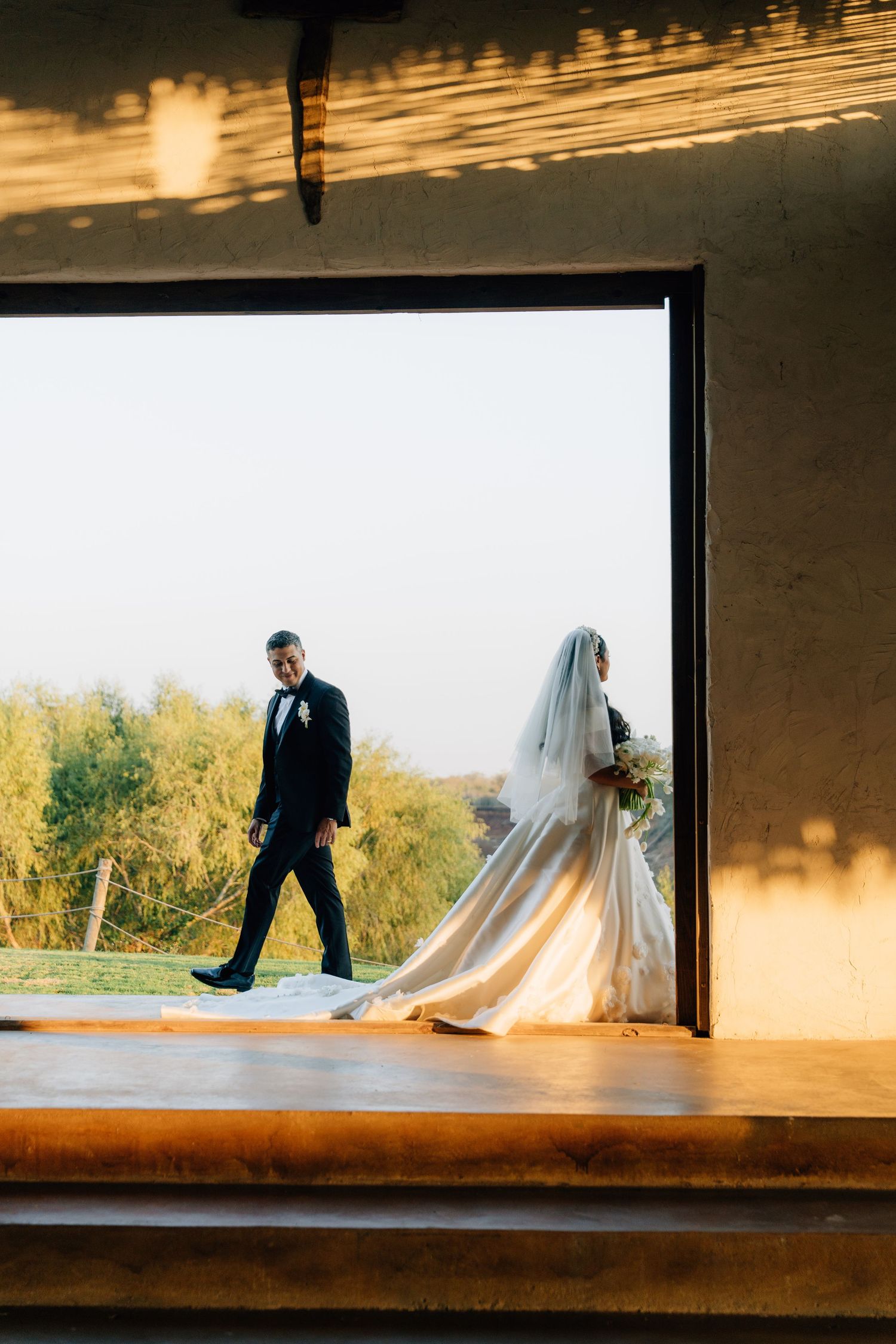 Wedding couple silhouetted against window light in artistic sequence showing movement across wooden ledge.