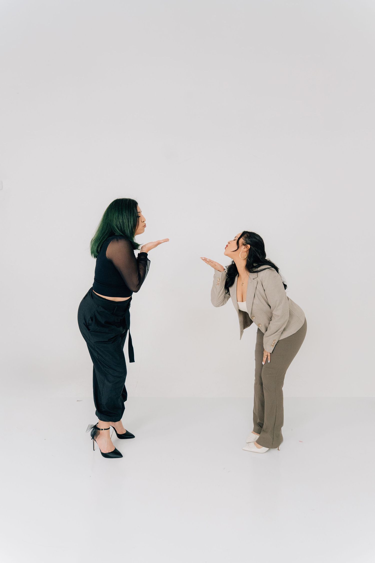 Two people gesture and interact playfully during a studio photoshoot.