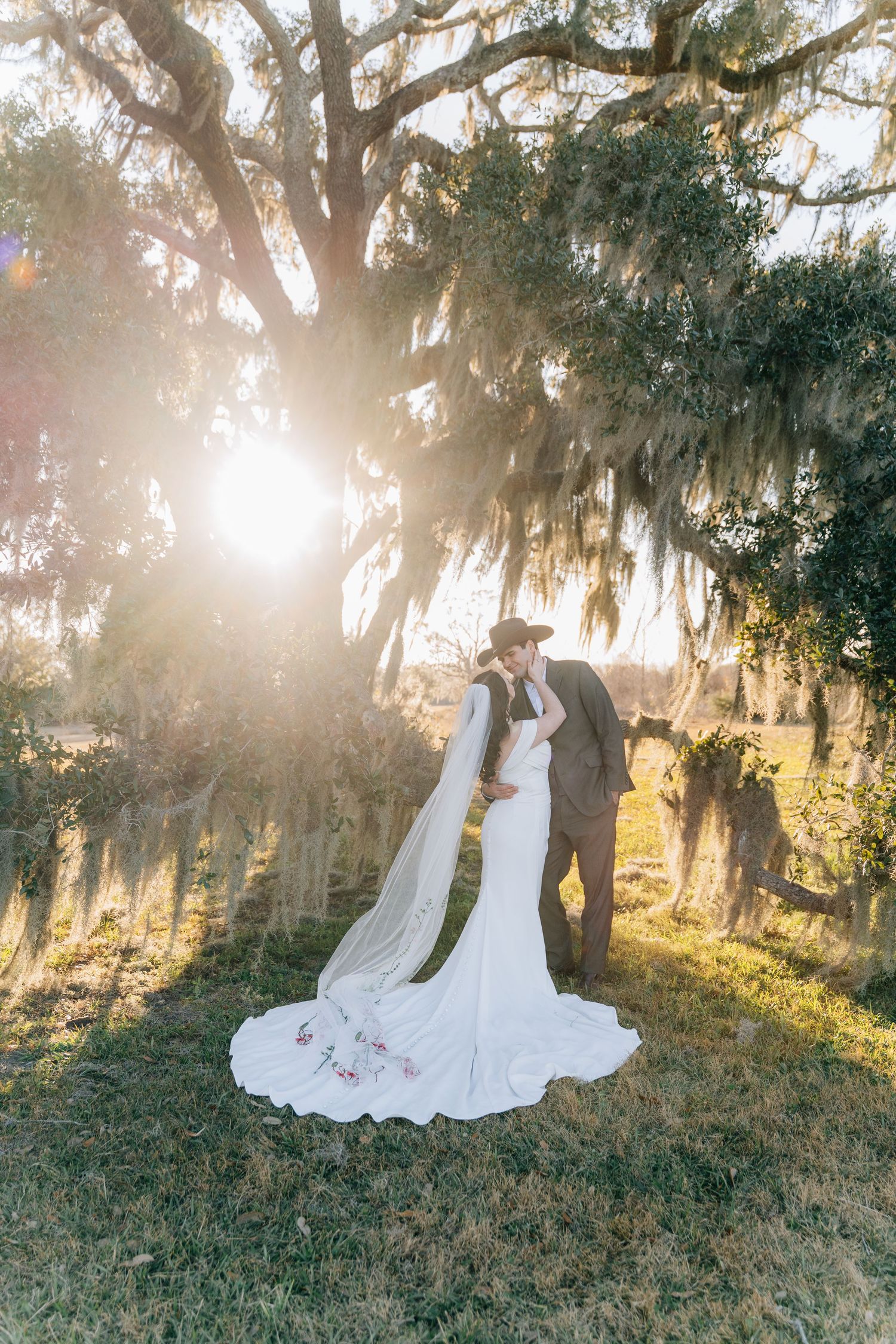 Dreamy sunset wedding photo with Spanish moss trees creating a magical backdrop.
