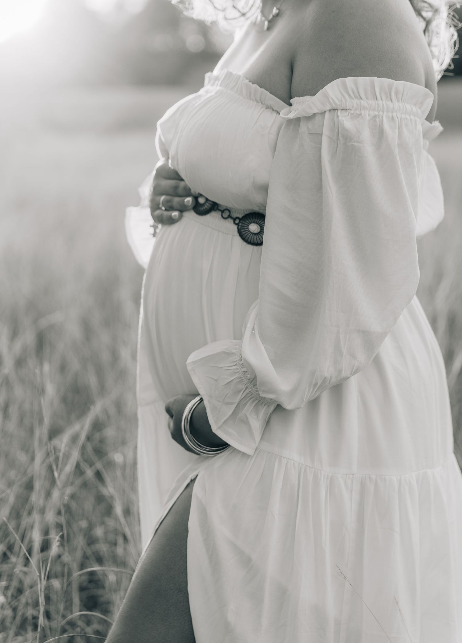 Close-up details of a flowing white dress in a natural outdoor setting.