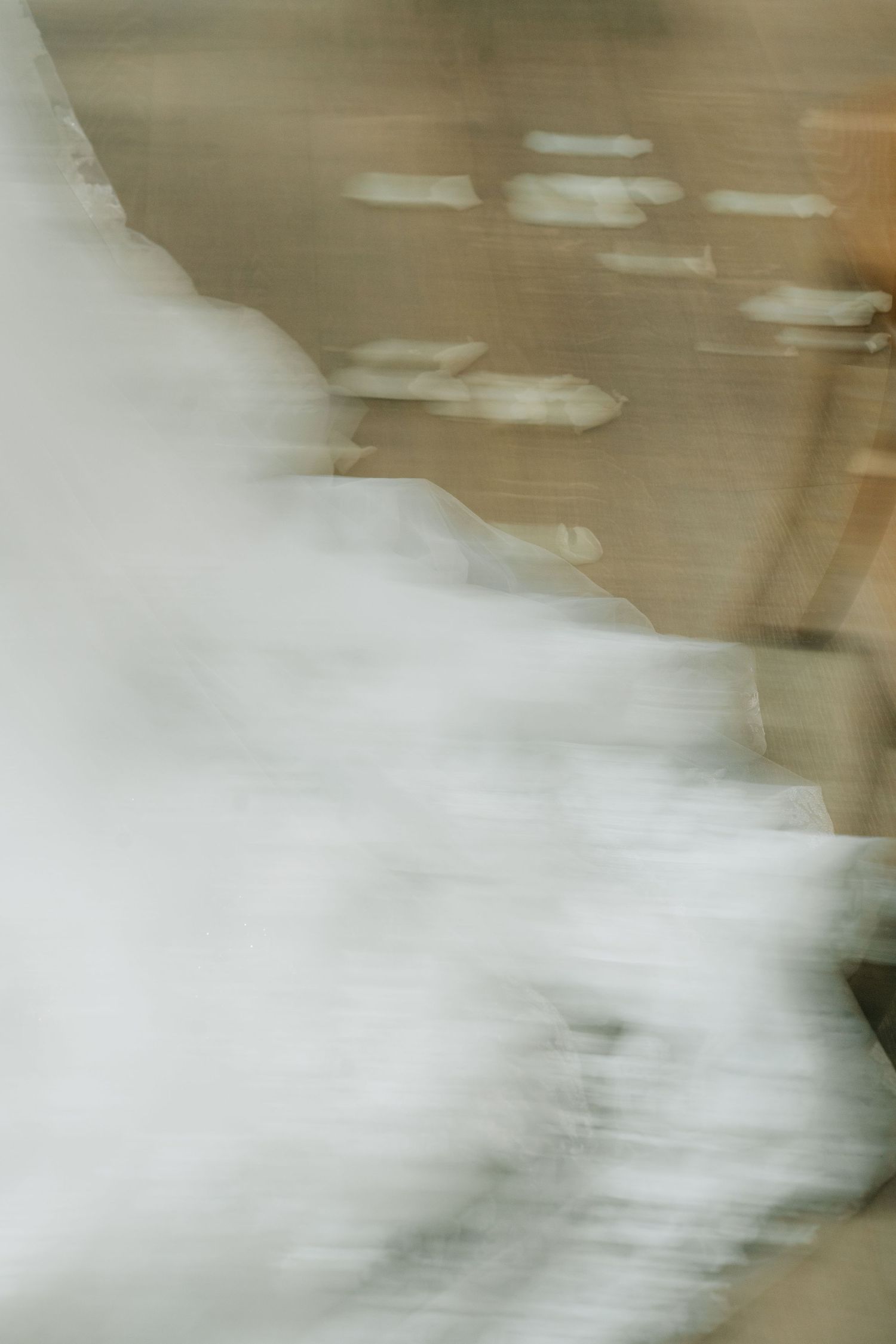 Abstract motion blur of white fabric against wooden floor.