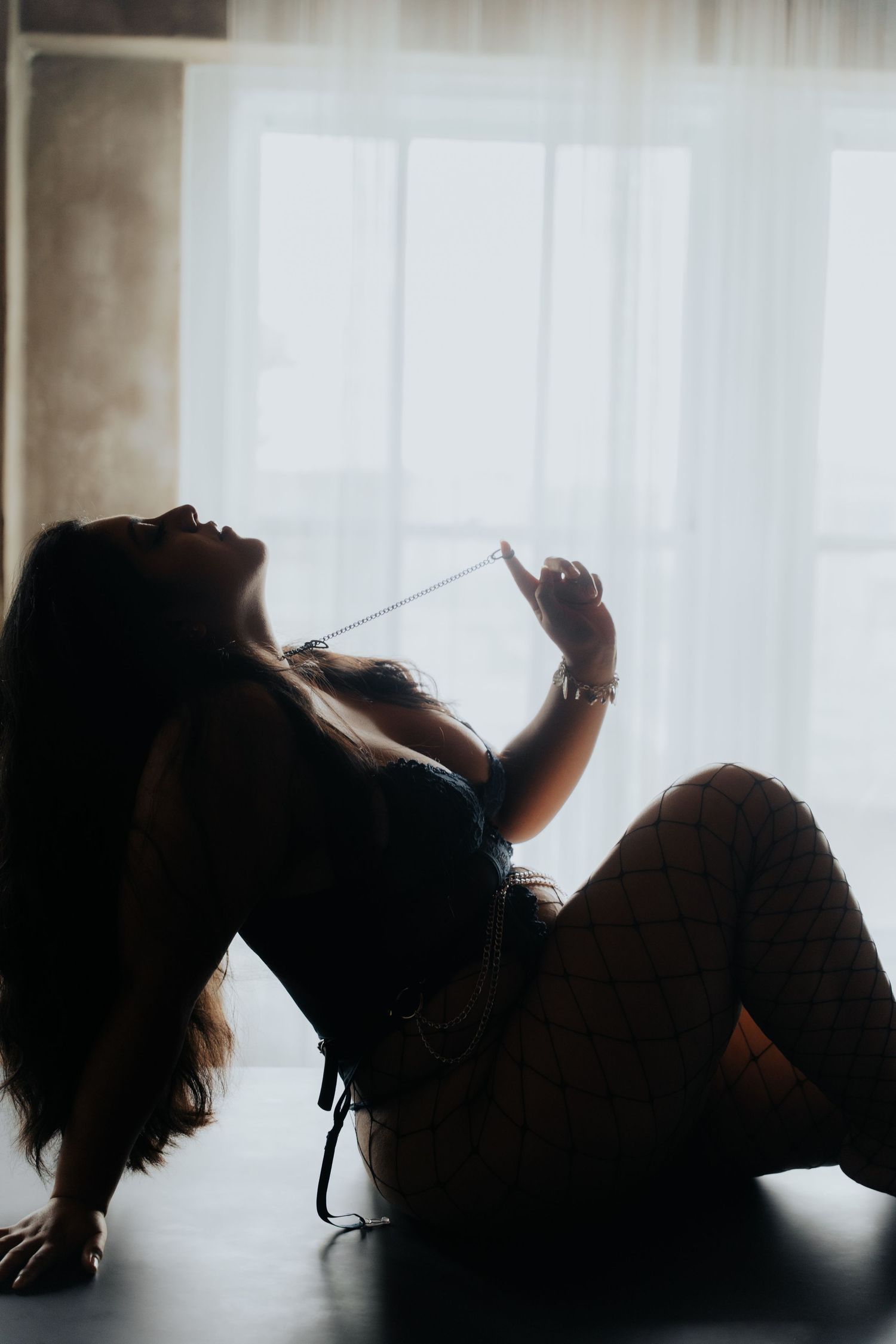 Artistic silhouette portrait in backlit window with dramatic shadows.