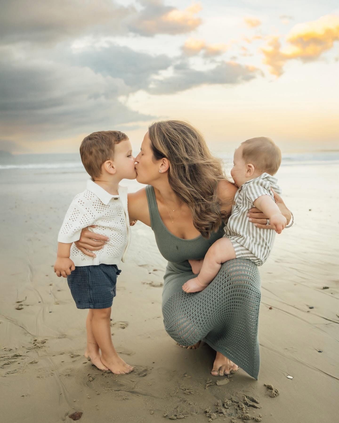 Sweet candid beach moments captured at sunset with waves in the background.