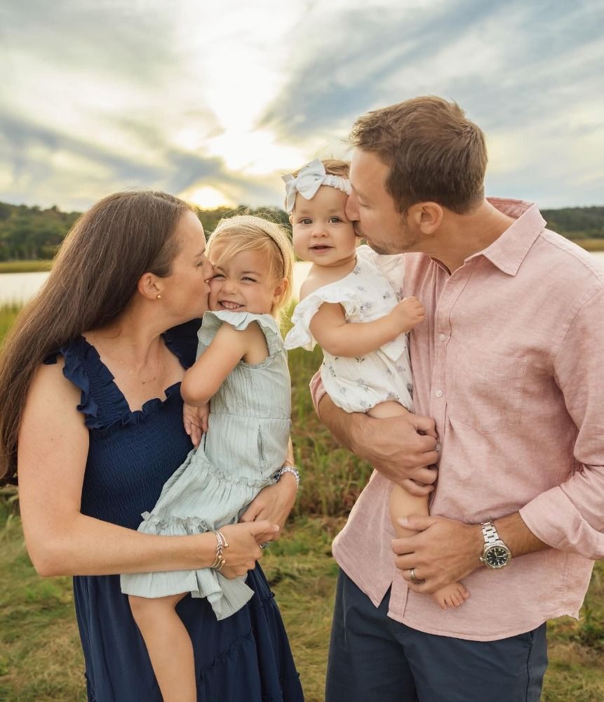 A family sharing a lighthearted moment together outdoors during golden hour.