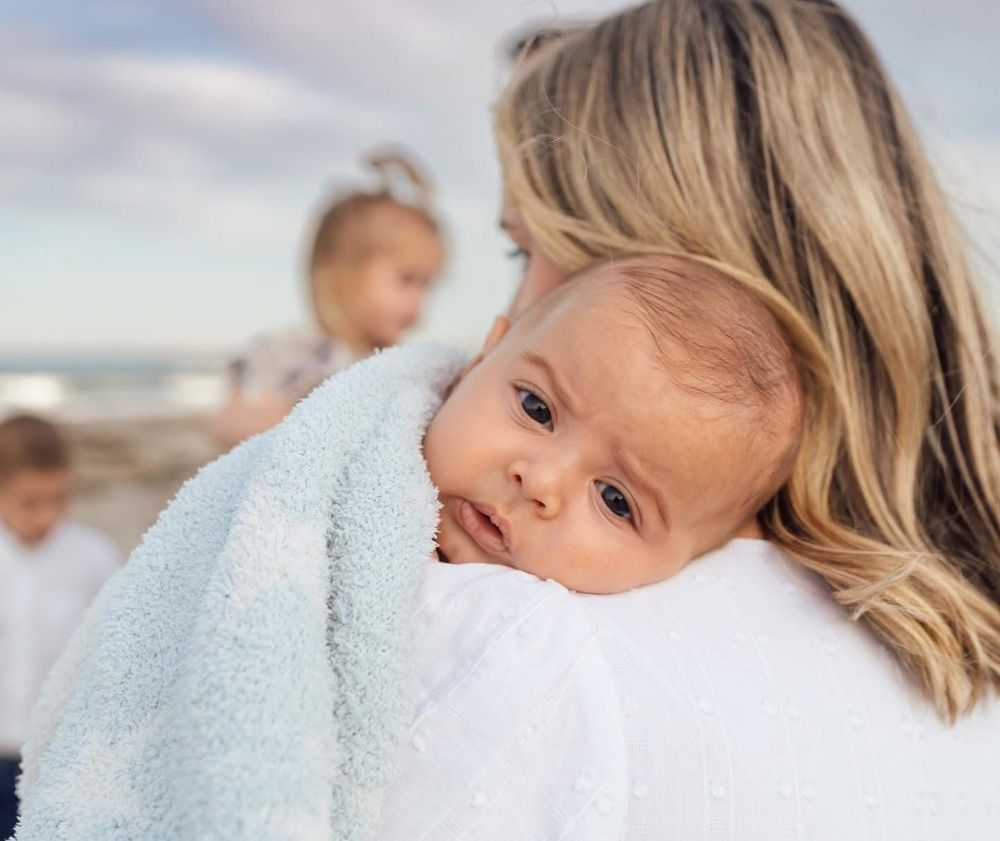 Close-up beach portrait with soft natural lighting and gentle expressions.