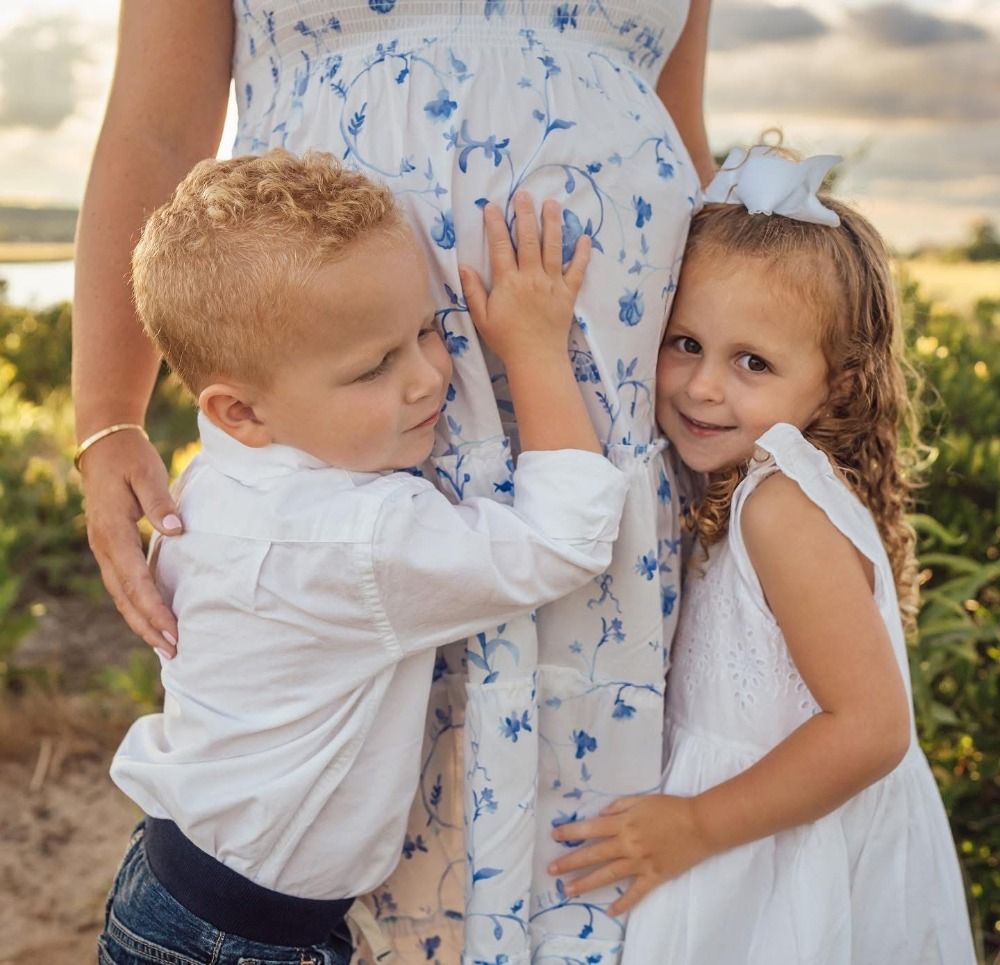 Close-up details of floral dress and white clothing during family photoshoot.
