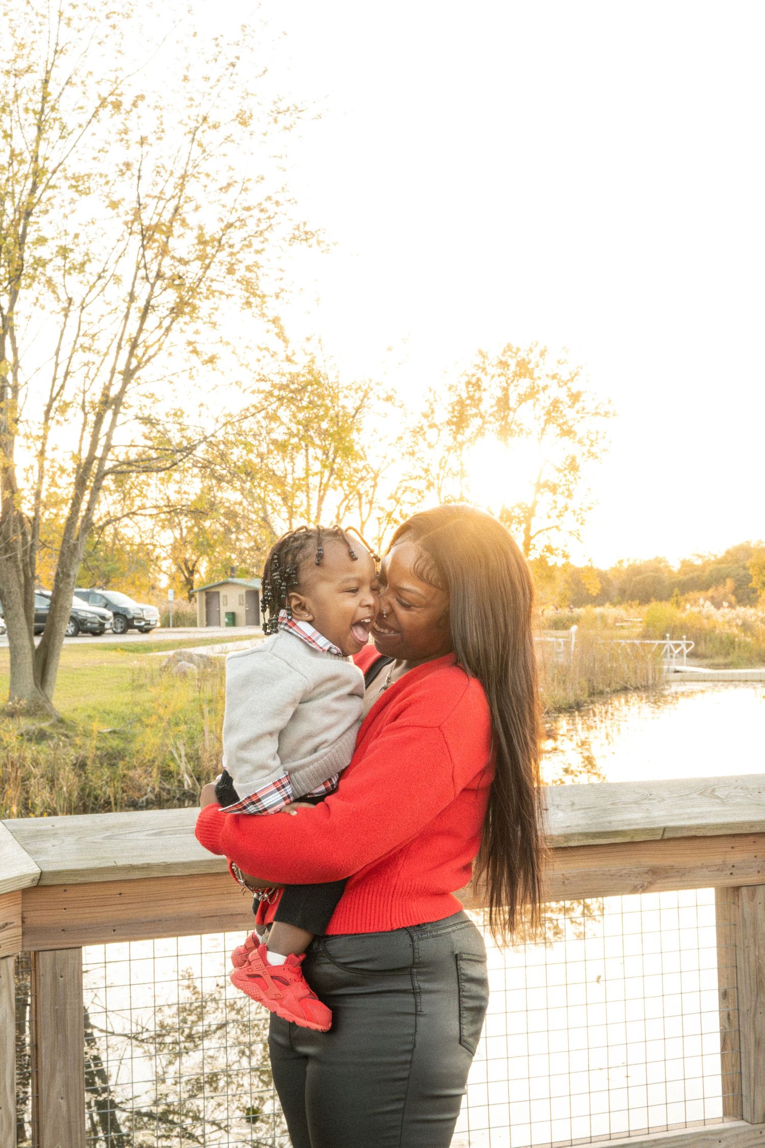 Two people share an embrace on wooden deck during golden hour sunset.