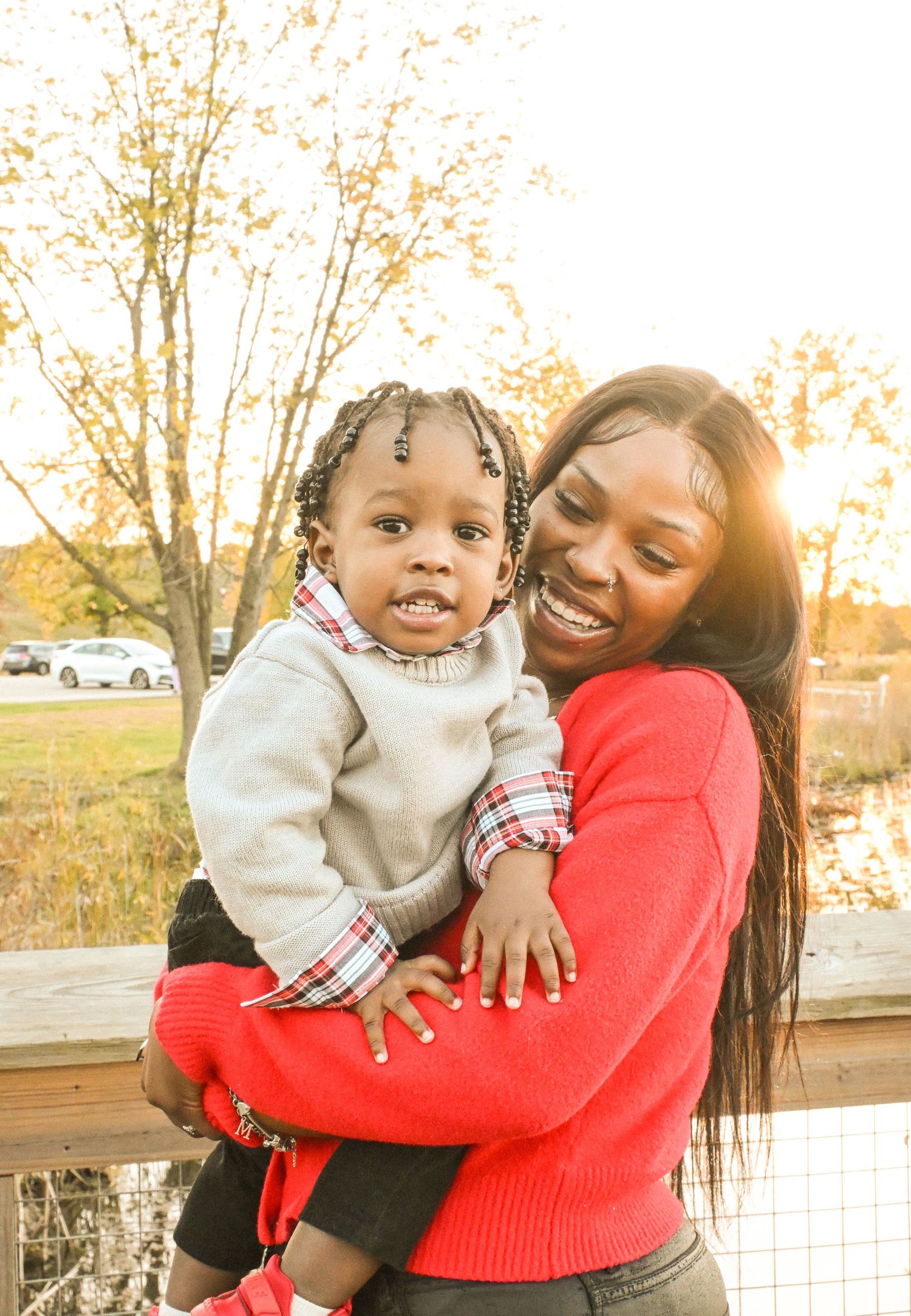 Joyful moment captured outdoors with warm sunset lighting through autumn trees.