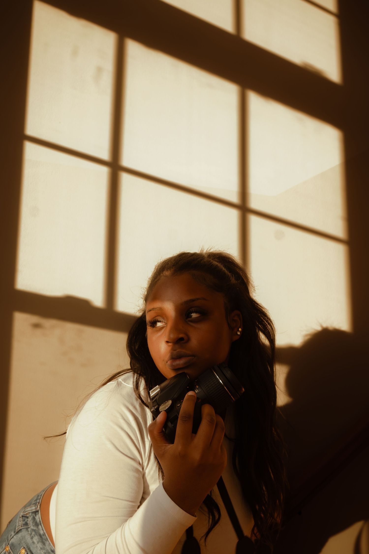 Dramatic shadows and window light create artistic silhouette effect in indoor setting.