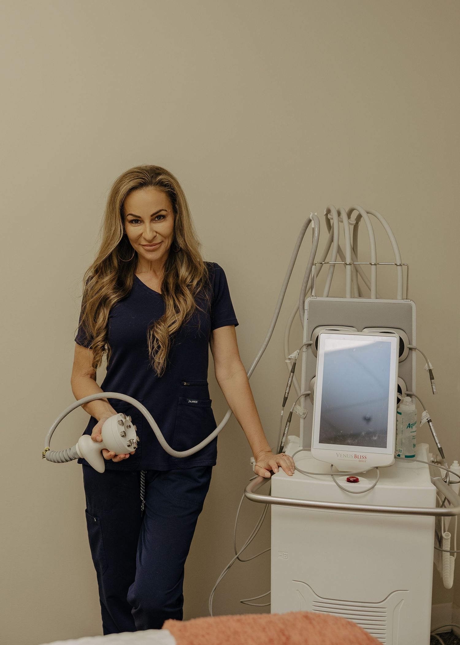 Medical professional showcasing aesthetic equipment in modern treatment room.