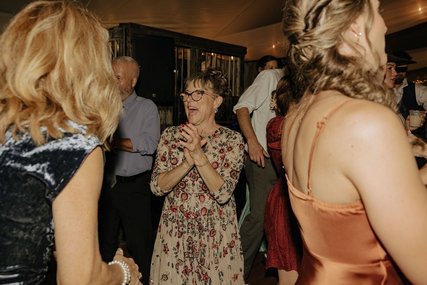 Wedding reception guests dancing and celebrating on the dance floor.