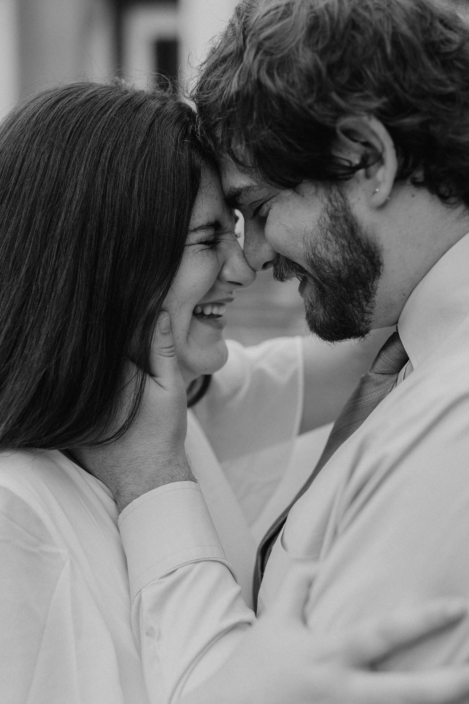 An intimate black and white portrait of a couple sharing a tender moment.
