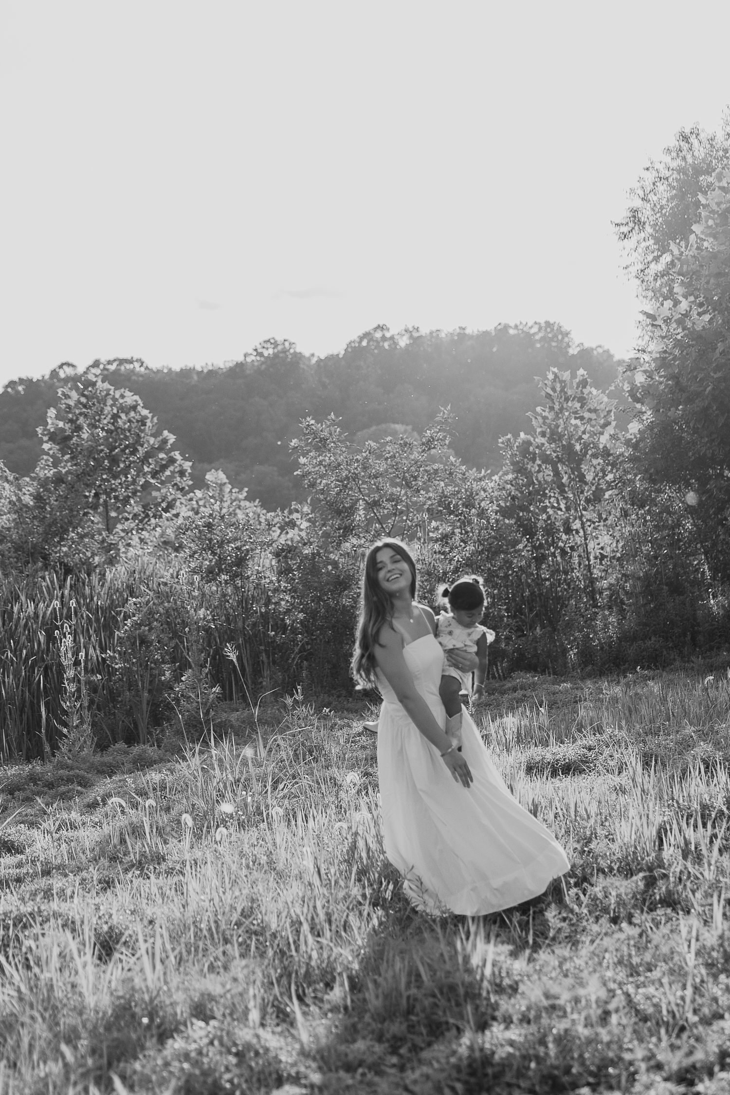 Black and white portrait of people dancing in a summer meadow.