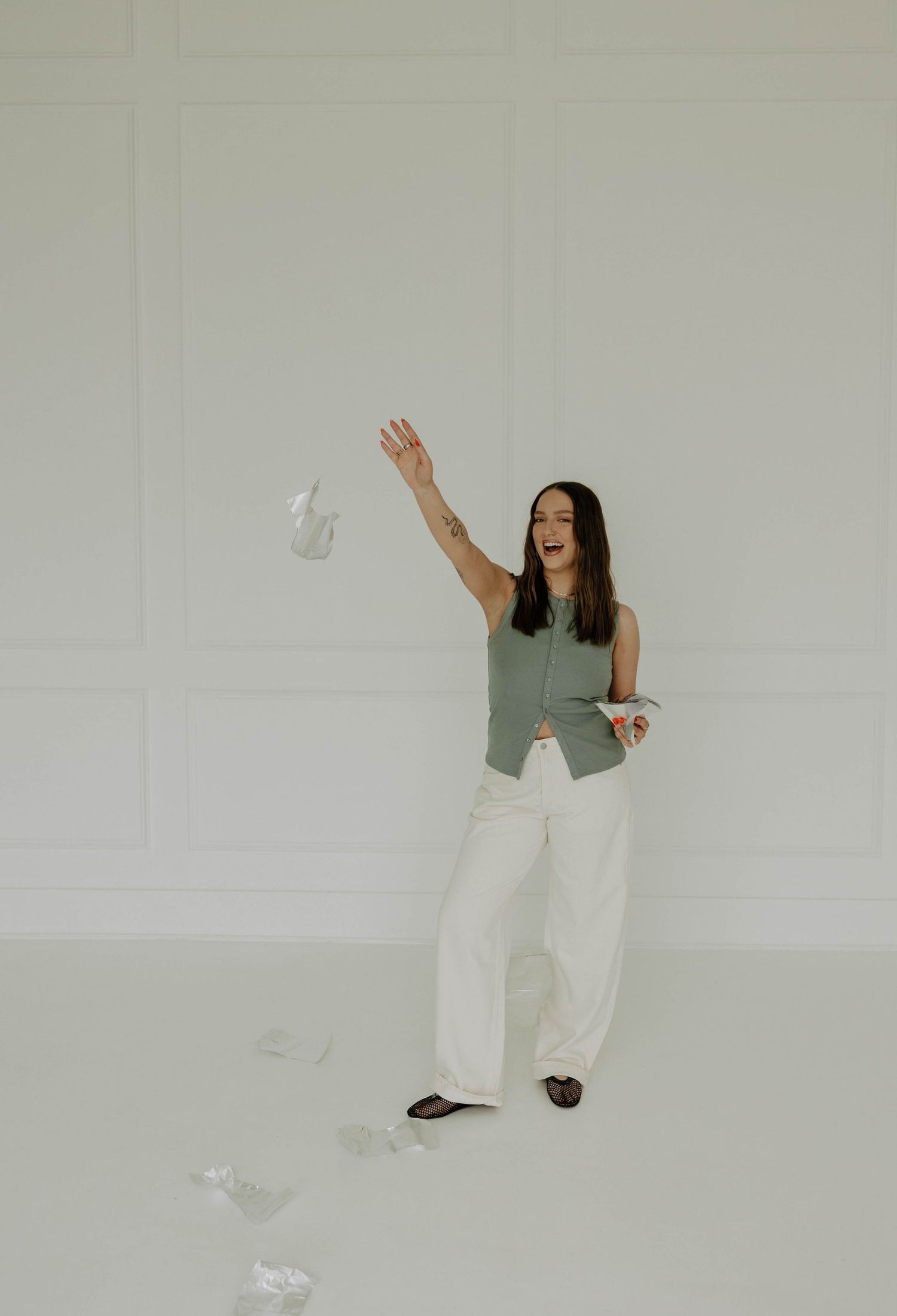 A figure in white pants dances expressively against a stark white background.