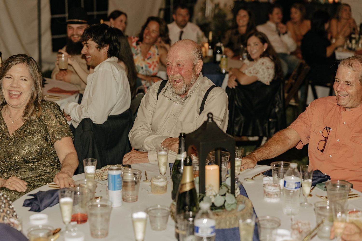 Wedding reception guests seated at long tables enjoying dinner and conversation.