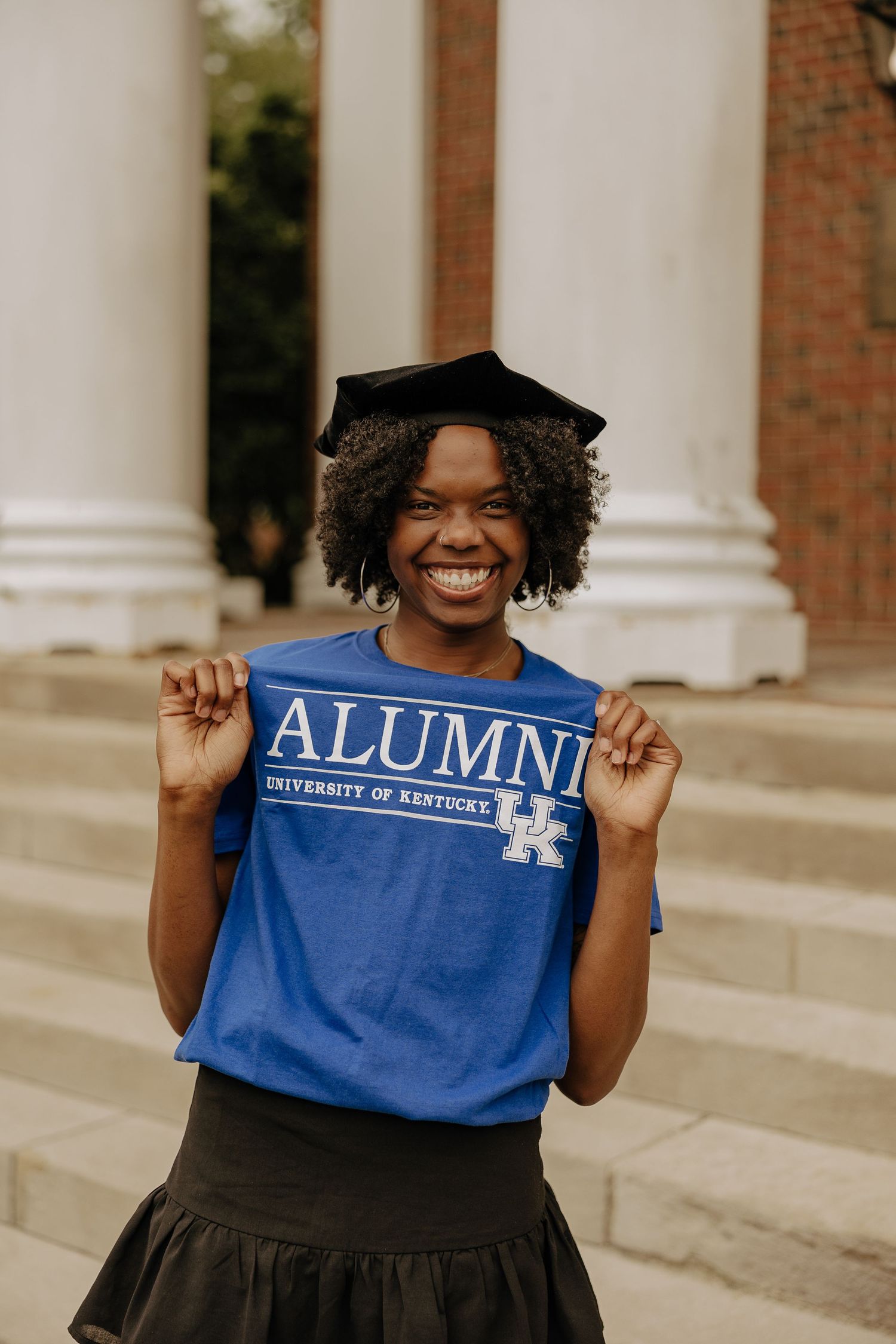 Graduate displays University of Kentucky alumni banner with enthusiasm.