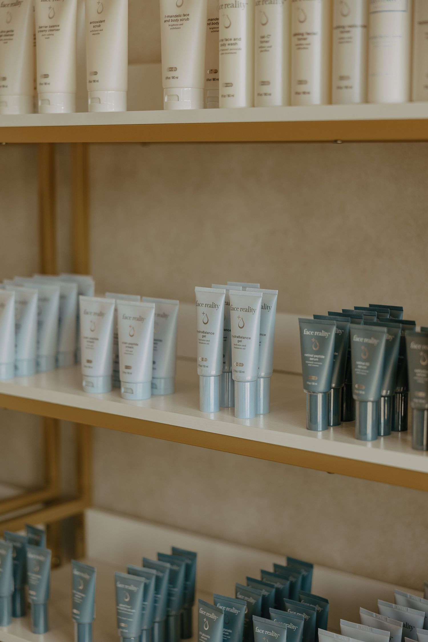 Organized display of skincare products on wooden shelves with white and gray packaging.