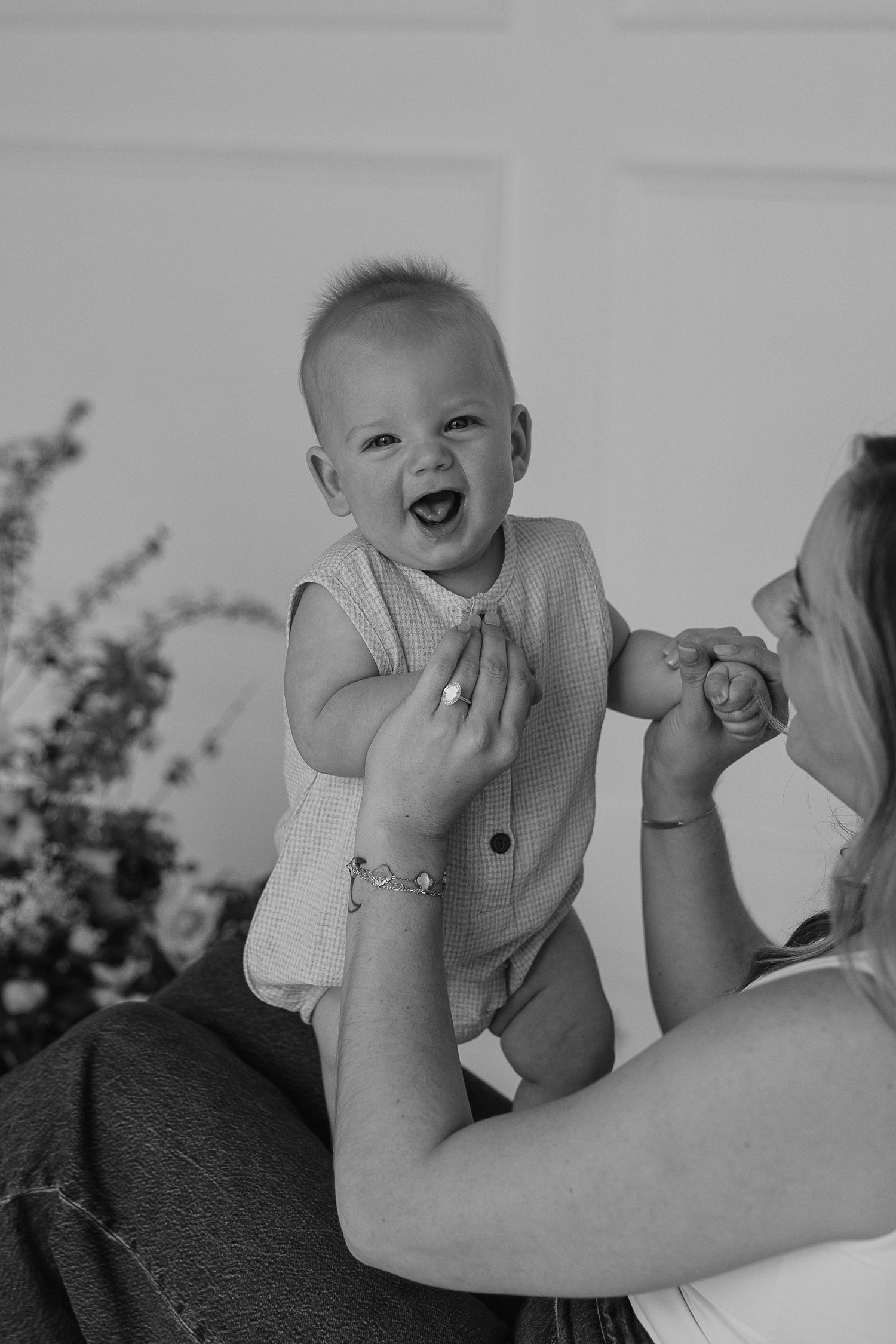 Black and white portraits capturing playful moments between parent and baby.
