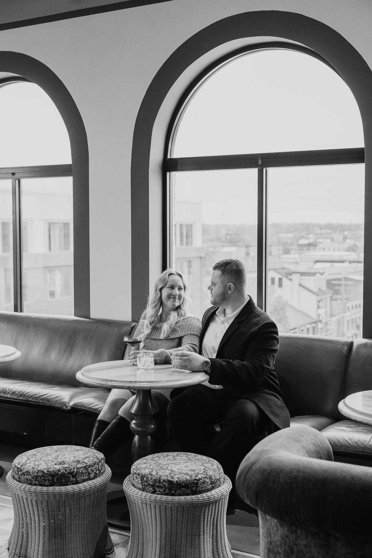 An elegant lounge area with arched windows overlooking a cityscape.