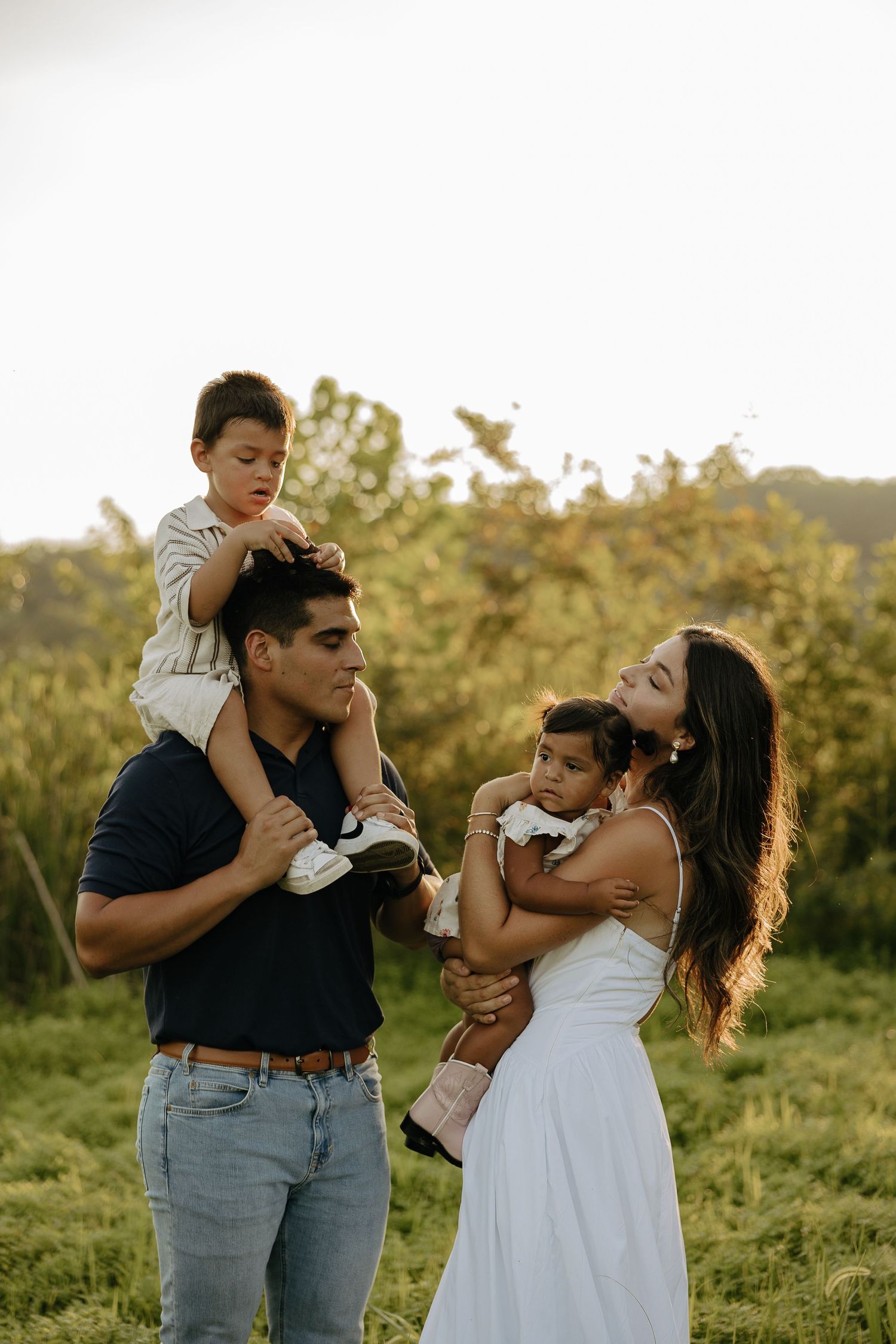 Family sharing loving embraces in a sun-kissed meadow.