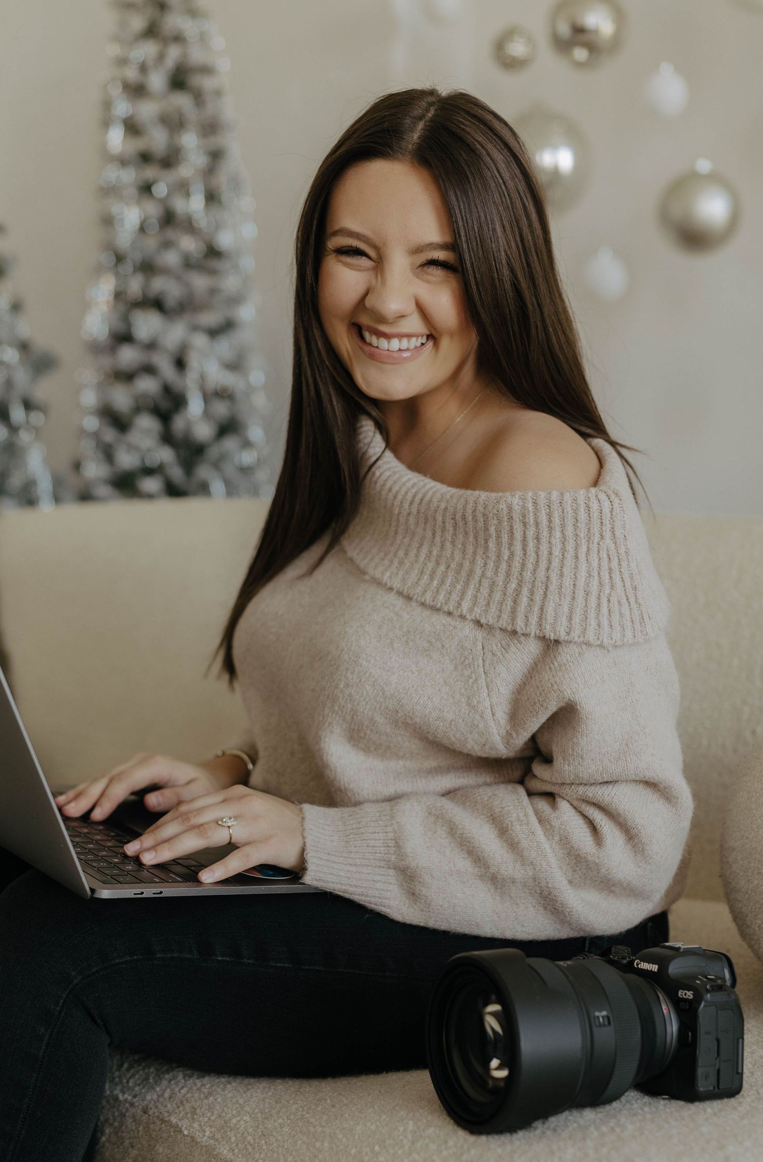 Holiday themed indoor photography session with Christmas trees and cozy sweater.