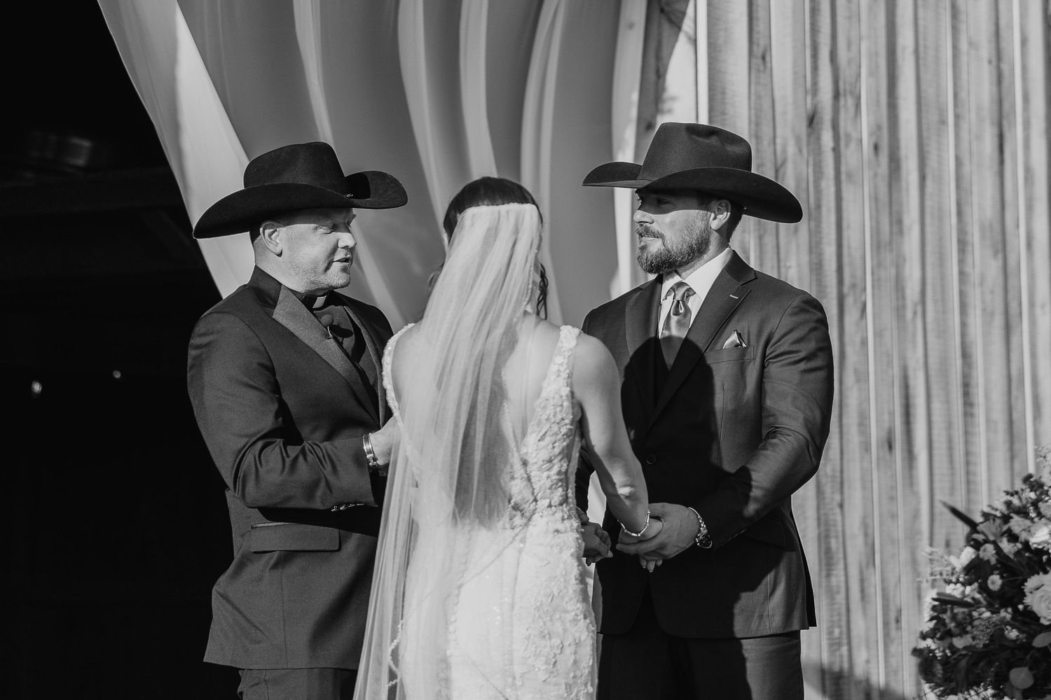 Black and white wedding ceremony moments captured inside rustic barn venue.