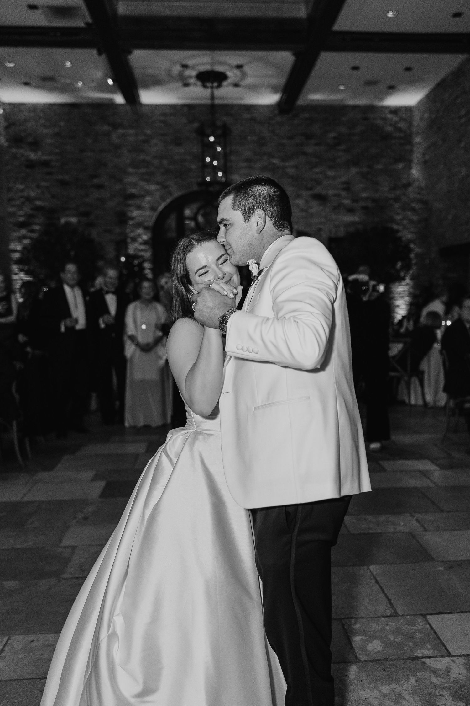 Intimate black and white dance moment at elegant wedding reception.