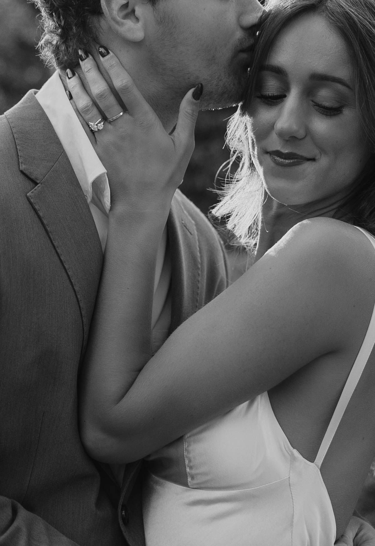 Black and white close-up photos of a romantic couple sharing intimate moments in formal attire.