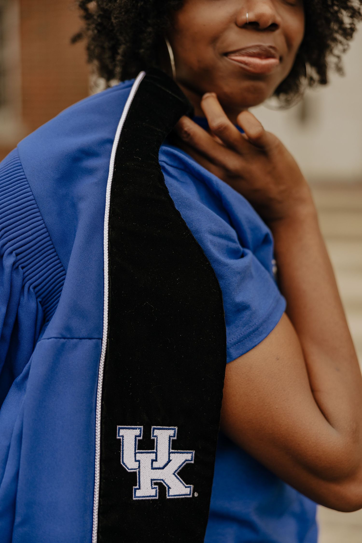 Close-up details of University of Kentucky graduation regalia showing emblems and trim.