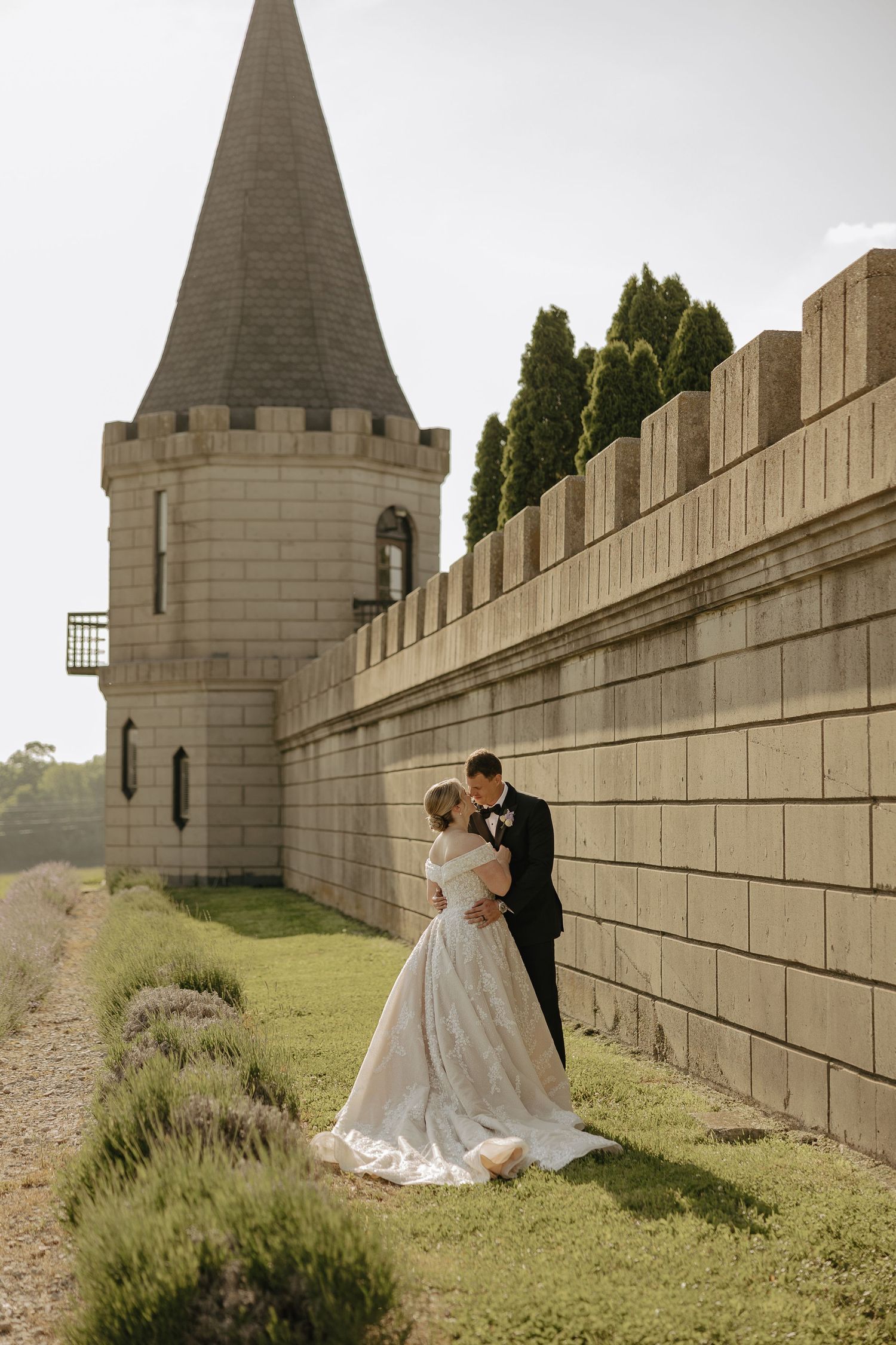 Castle wedding venue with stone tower and crenellated walls surrounded by lavender.