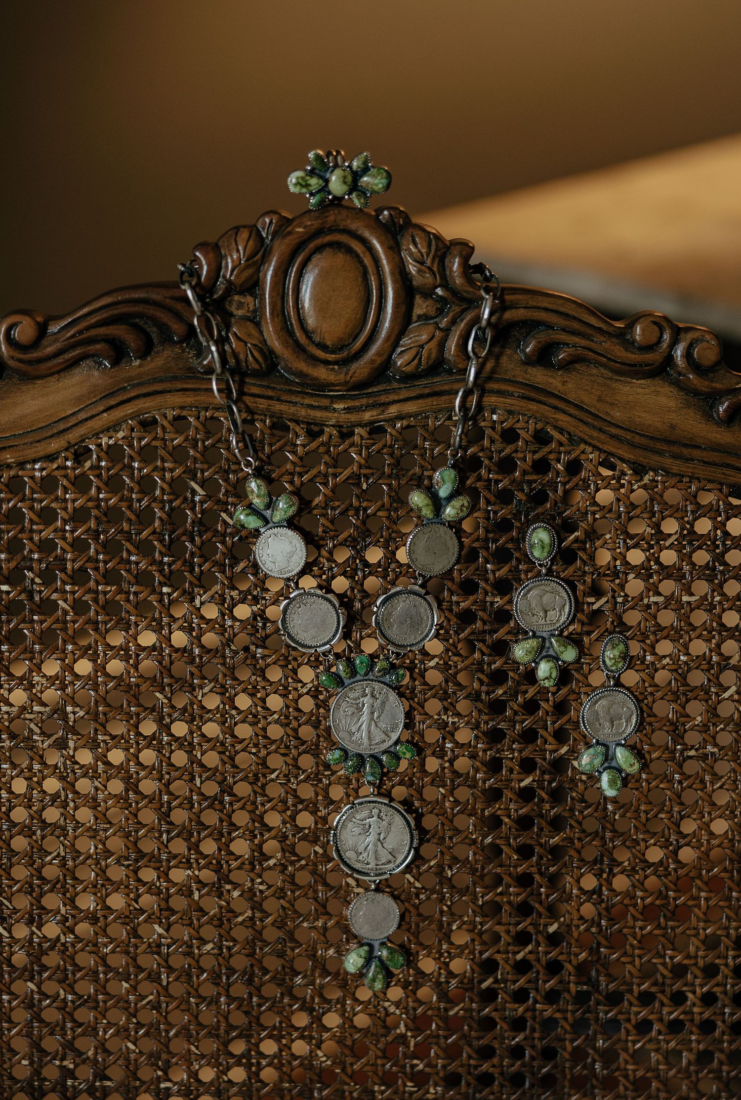 Vintage ornate metal headboard with decorative coins and turquoise floral accents in warm lighting.